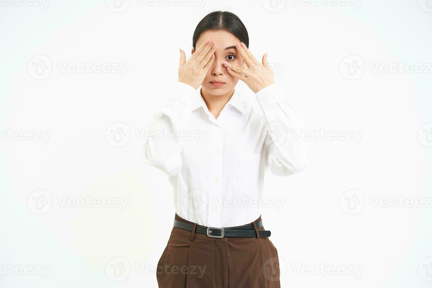 Portrait of young asian woman covers her eyes with hands, hides from something, white background photo