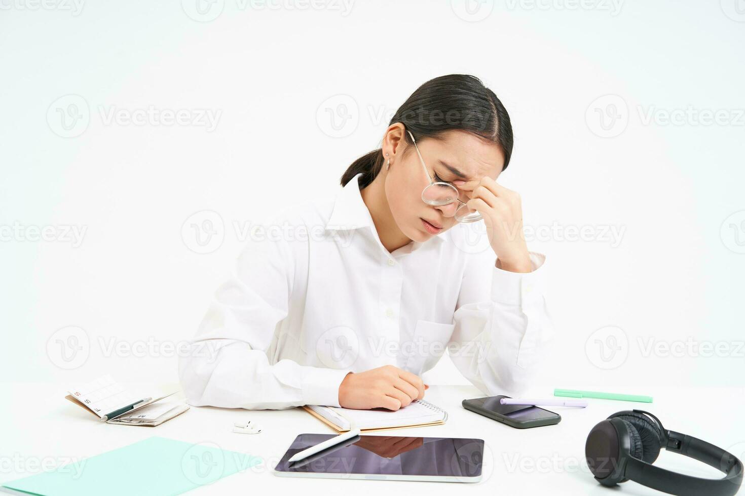 Workplace and business. Portrait of tired woman in office, company employee sits at desk with exhausted face, touches her head, has headache, white background photo