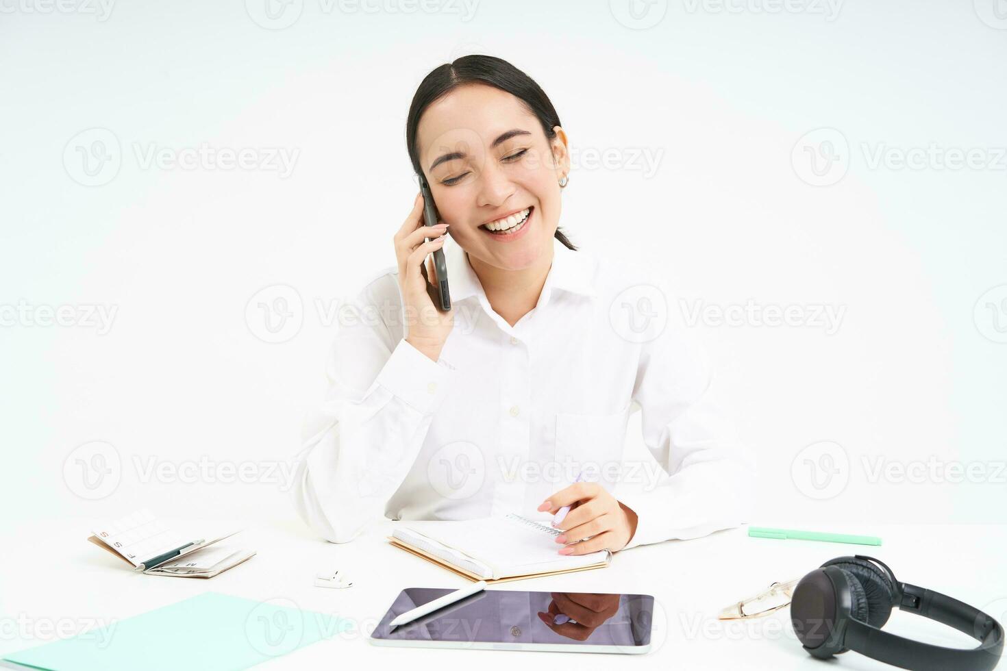 Portrait of smiling woman entrepreneur talking with her client on mobile phone, speaking with someone on cellphone, white background photo