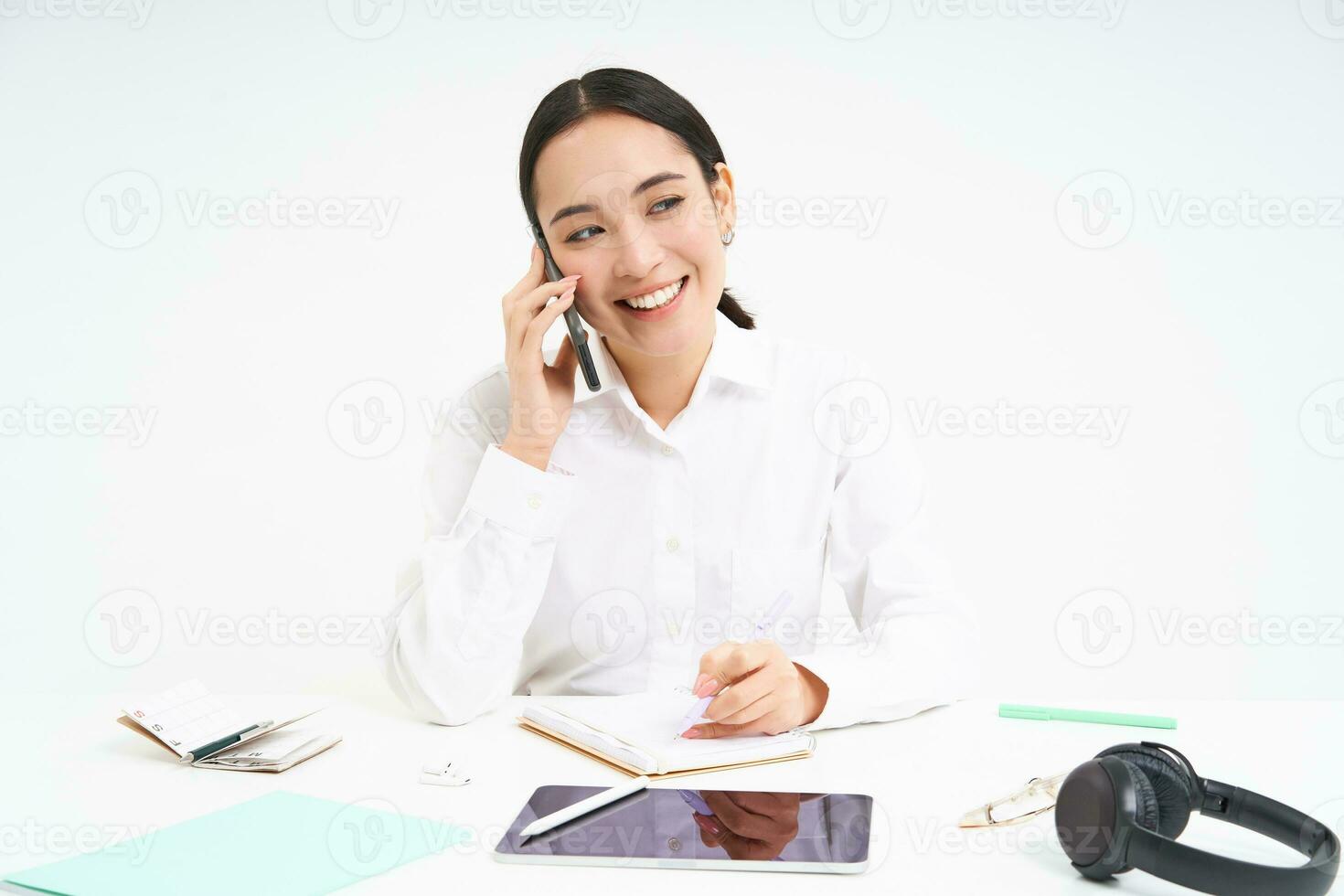 Portrait of smiling woman entrepreneur talking with her client on mobile phone, speaking with someone on cellphone, white background photo