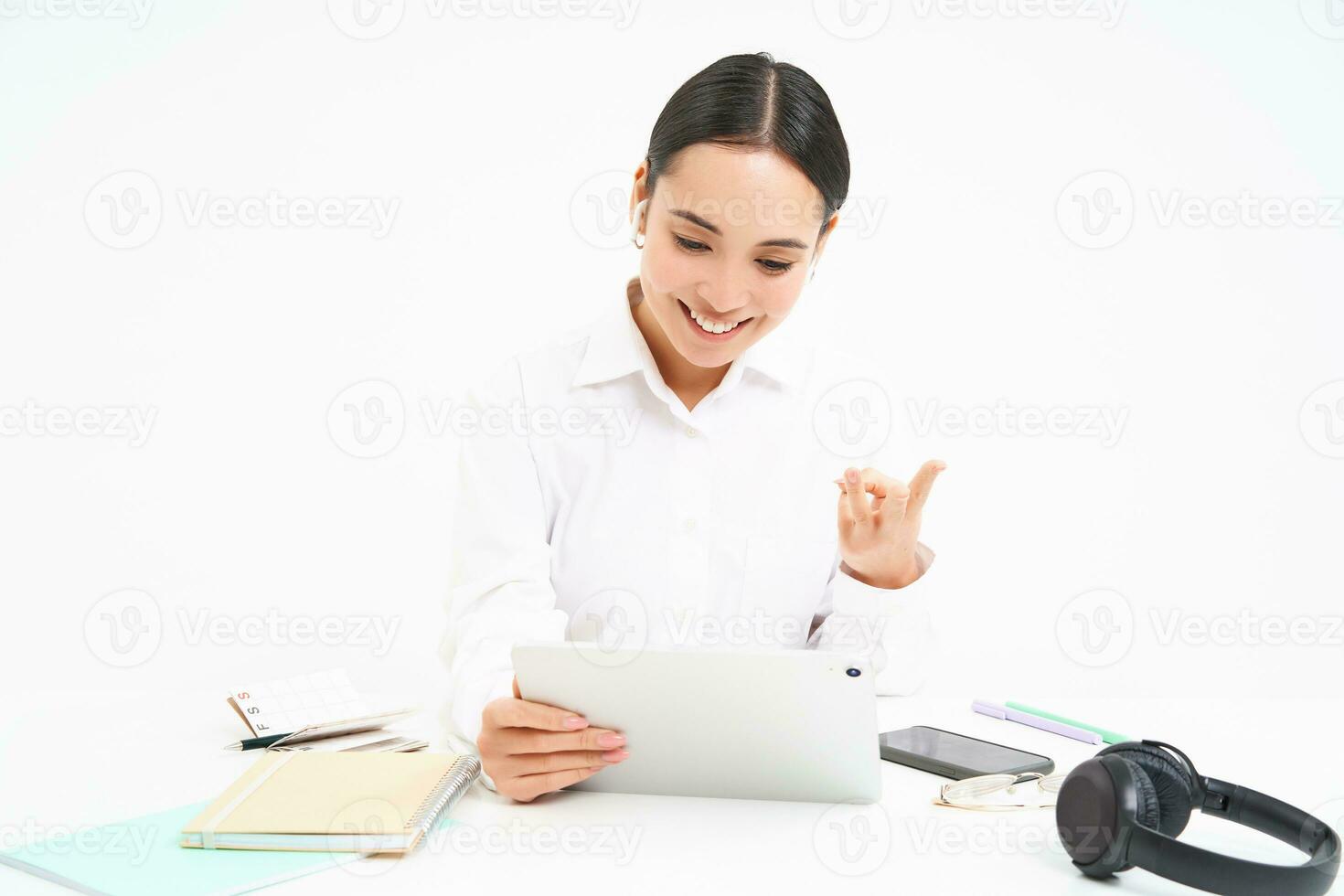 Image of saleswoman, asian businesswoman video chats, has online meeting on digital tablet, sits in her office, isolated on white background photo