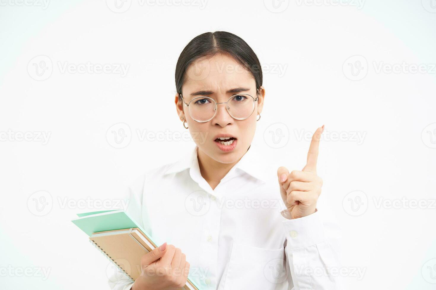 Disappointed, serious japanese teacher, woman shakes finger in disapproval, scolding student, standing over white background photo
