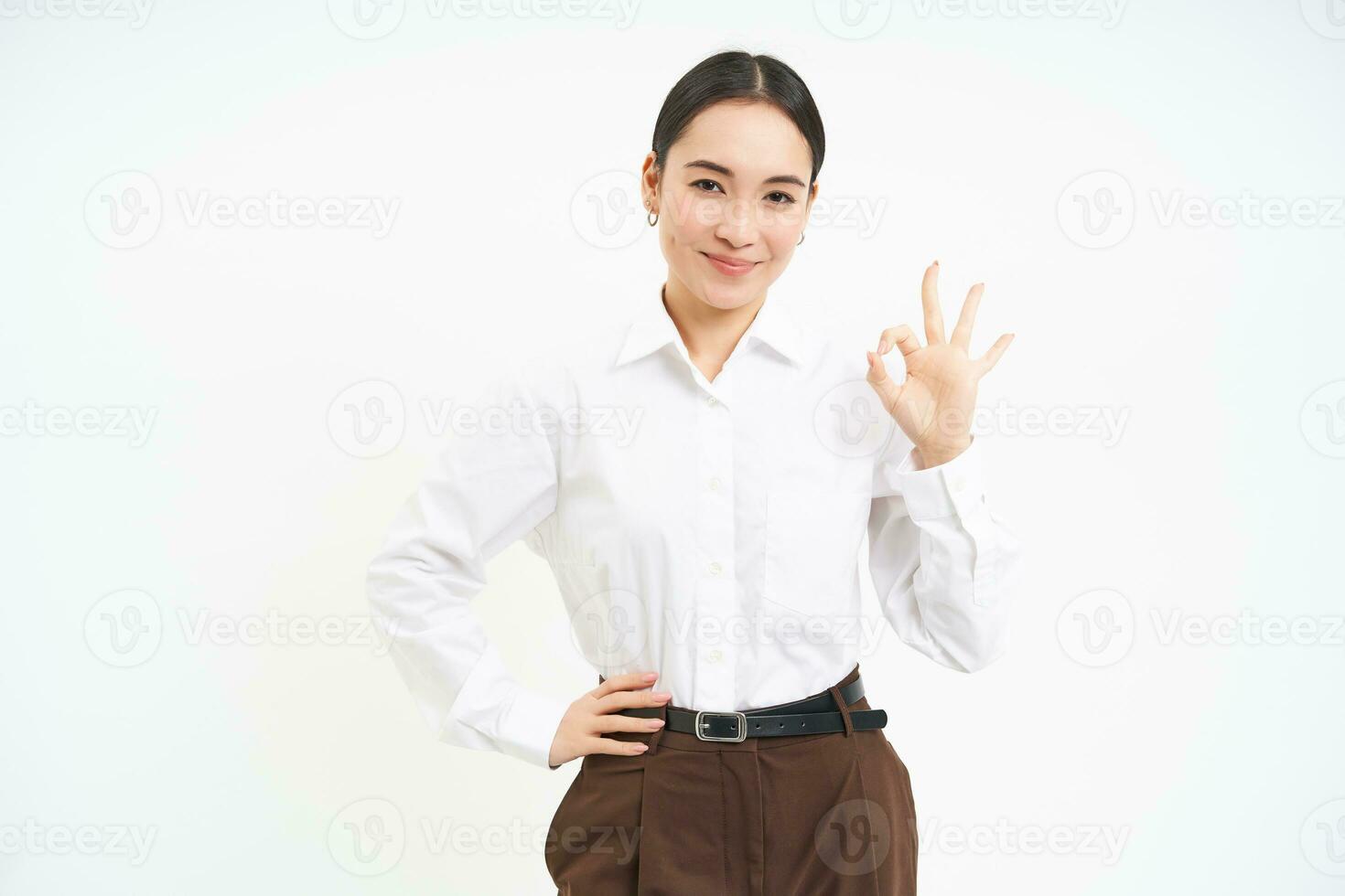 Business. Professional businesswoman, shows okay, approval gesture, recommends smth, white studio background photo