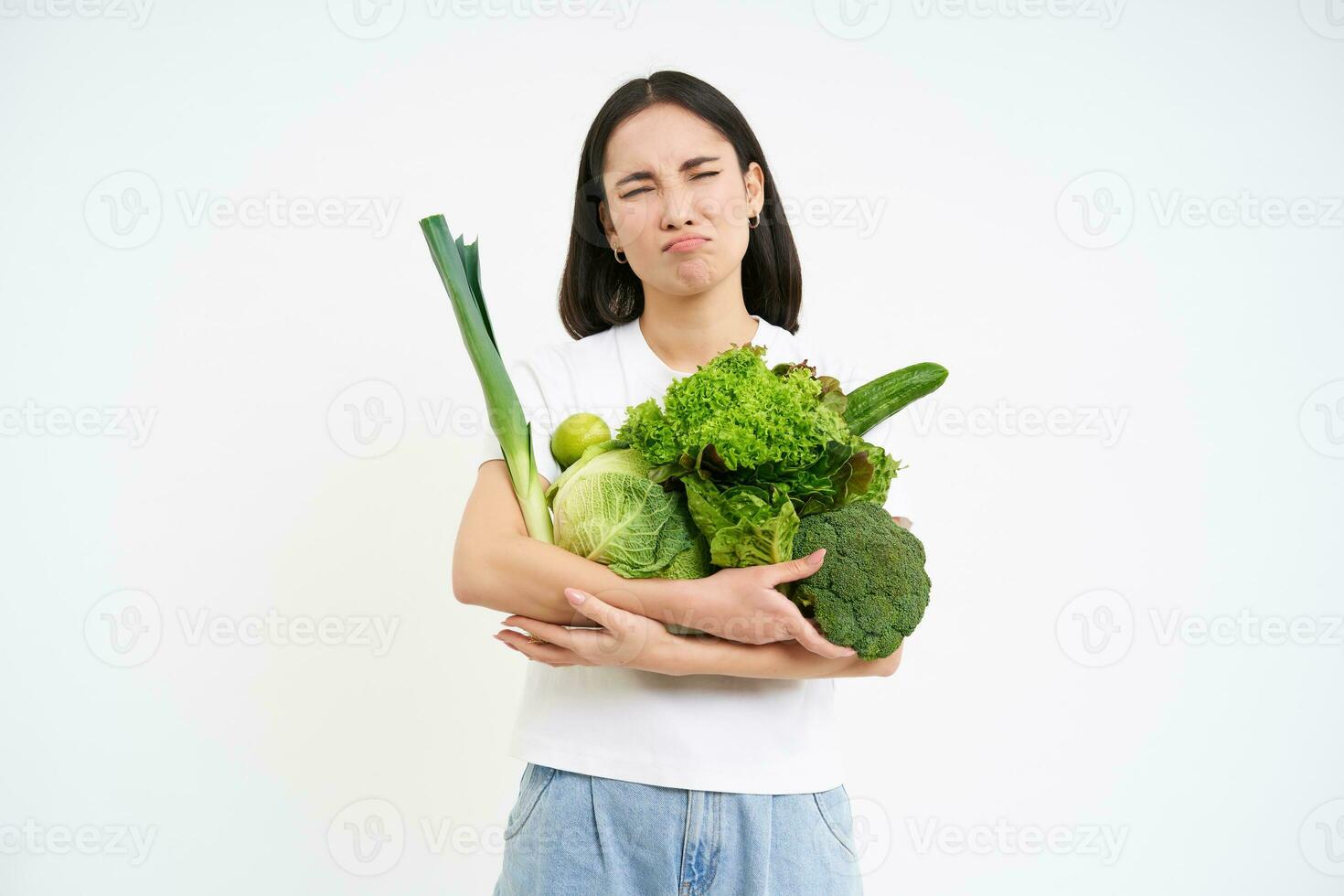 mujer con disgustado rostro, participación verduras, verde orgánico alimento, odia dietas y desintoxicación, blanco antecedentes foto