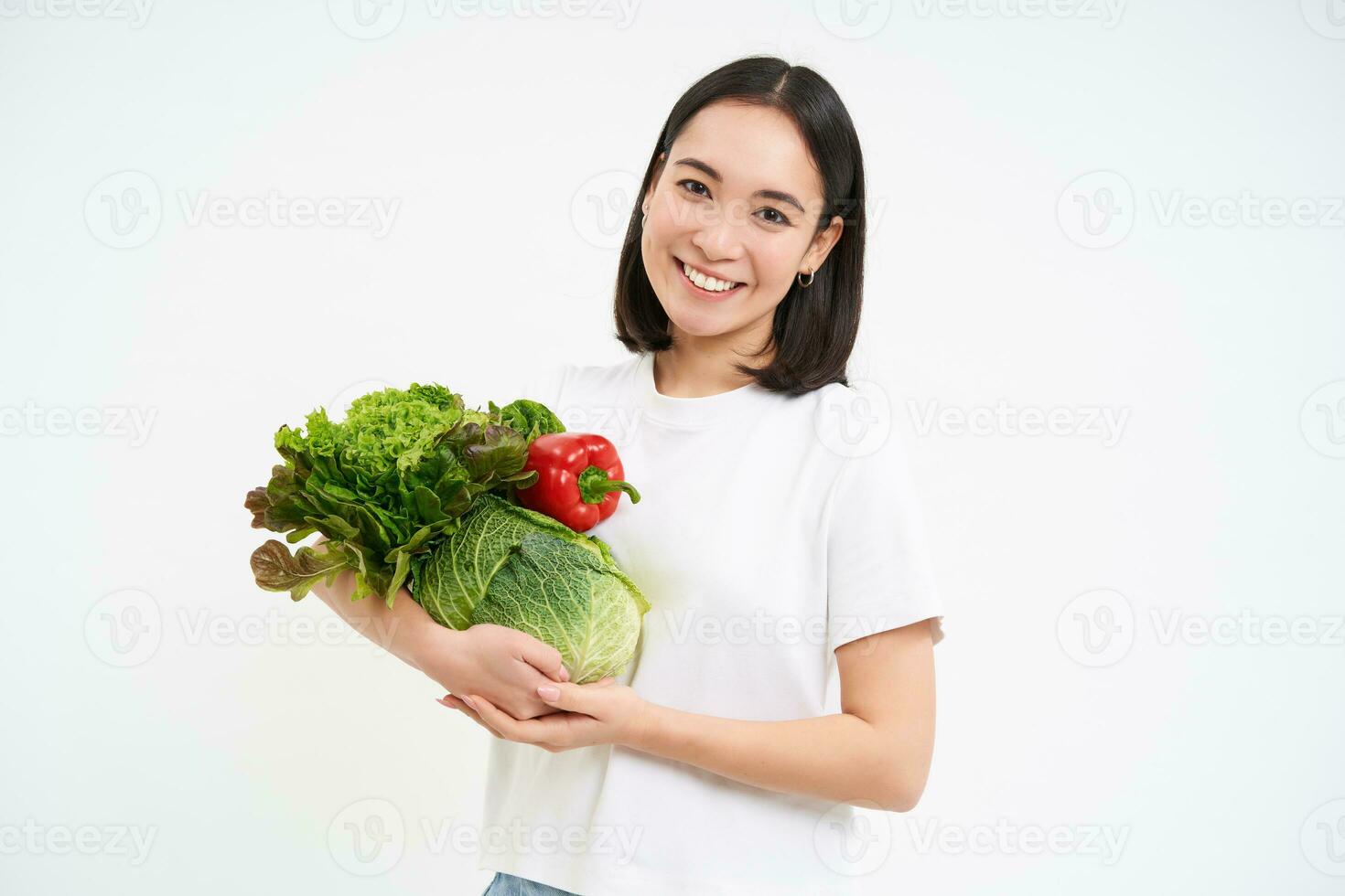 retrato de hermosa sonriente coreano mujer, sostiene bouquette de verduras, comprando verde orgánico comida a mercado, blanco antecedentes foto