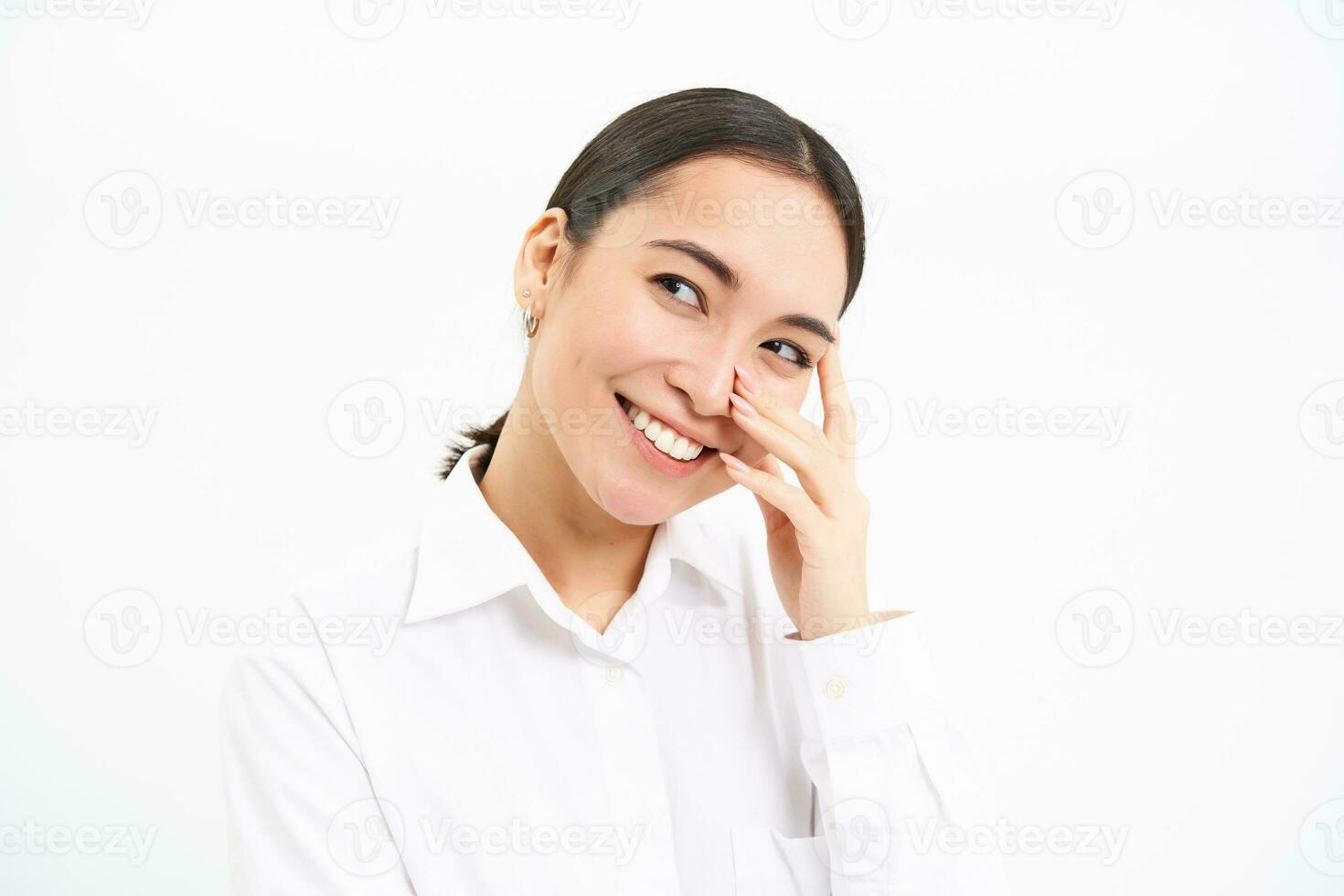 Beautiful young korean woman, laughing and smiling, showing sincere happiness and joy, standing over white background photo