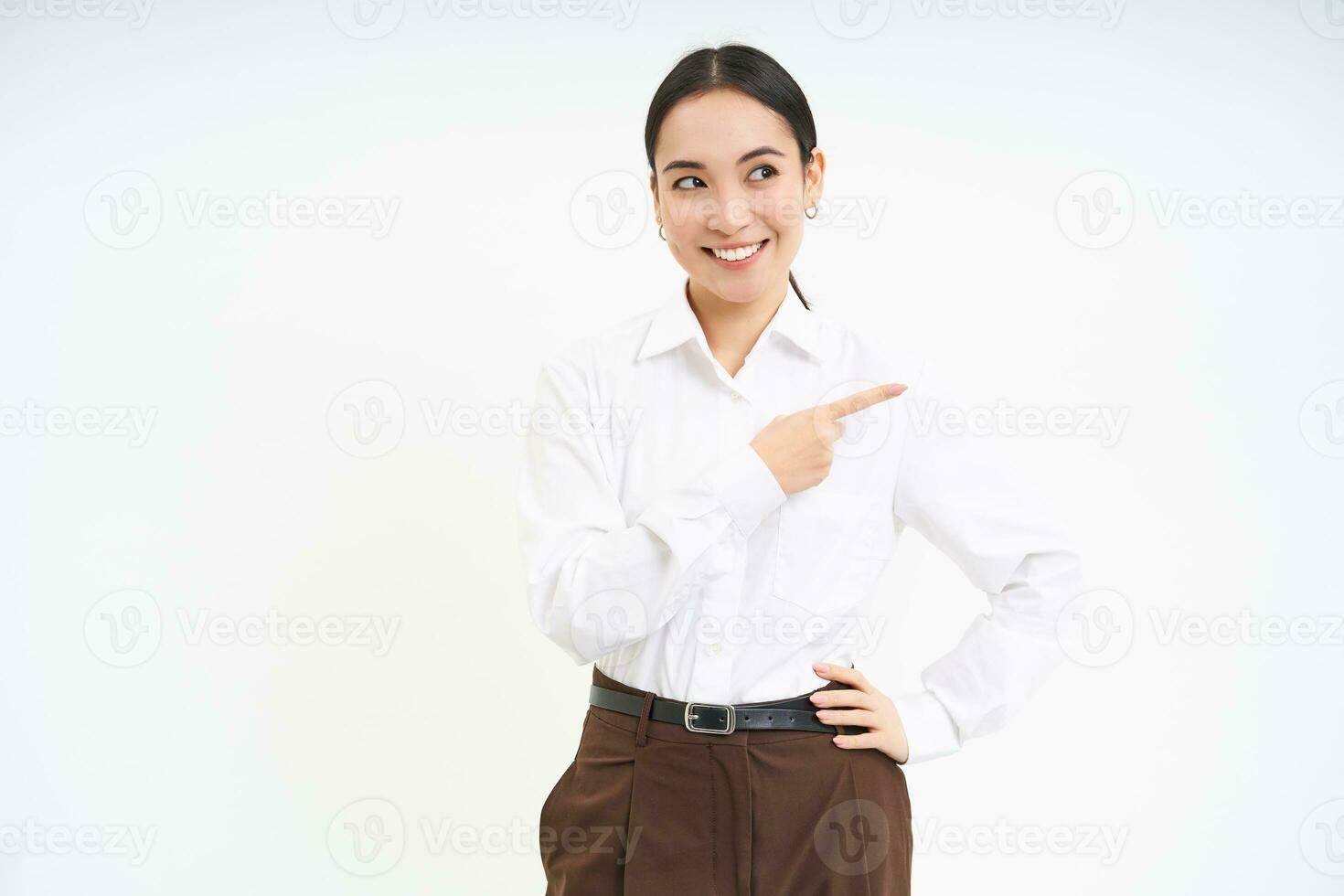 Business. Corporate asian woman points finger right, shows advertisement, banner promo, stands over white background photo