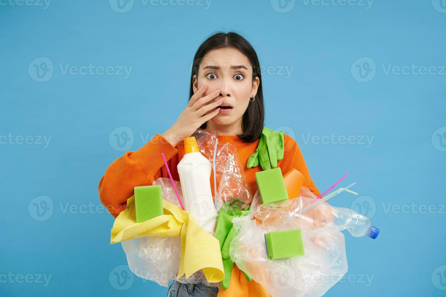 Shocked asian woman, looks embarrassed at something horrible, holding ...