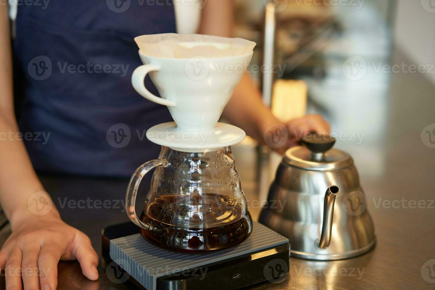 Close up of filter coffee brewing kit and kettle, cafe barista preparing filter at the counter photo