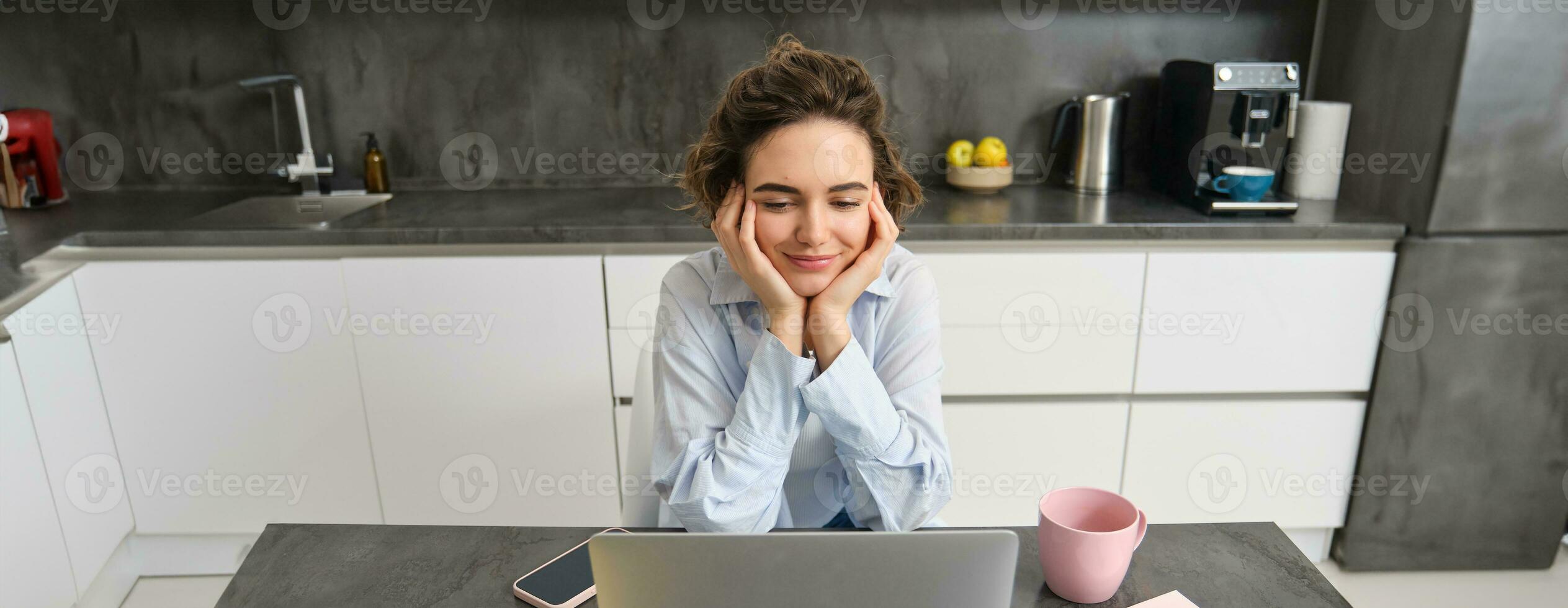 Portrait of young woman watching video on laptop, looking at computer