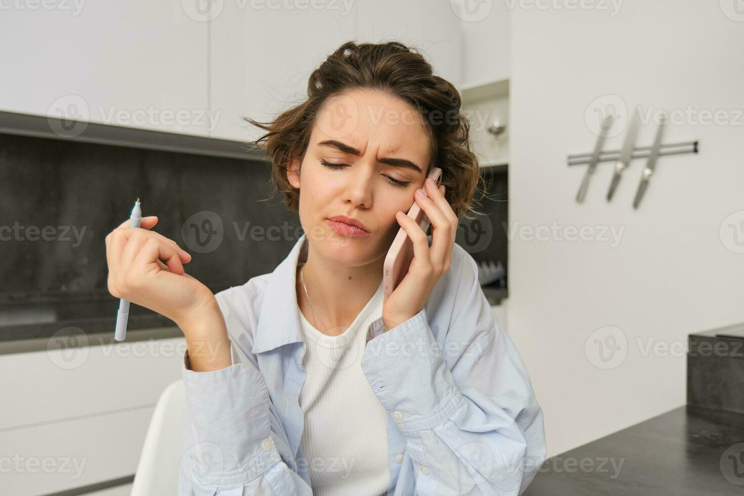 Image of woman with confused face, answering phone call and looking puzzled, cant understand conversation, using smartphone photo