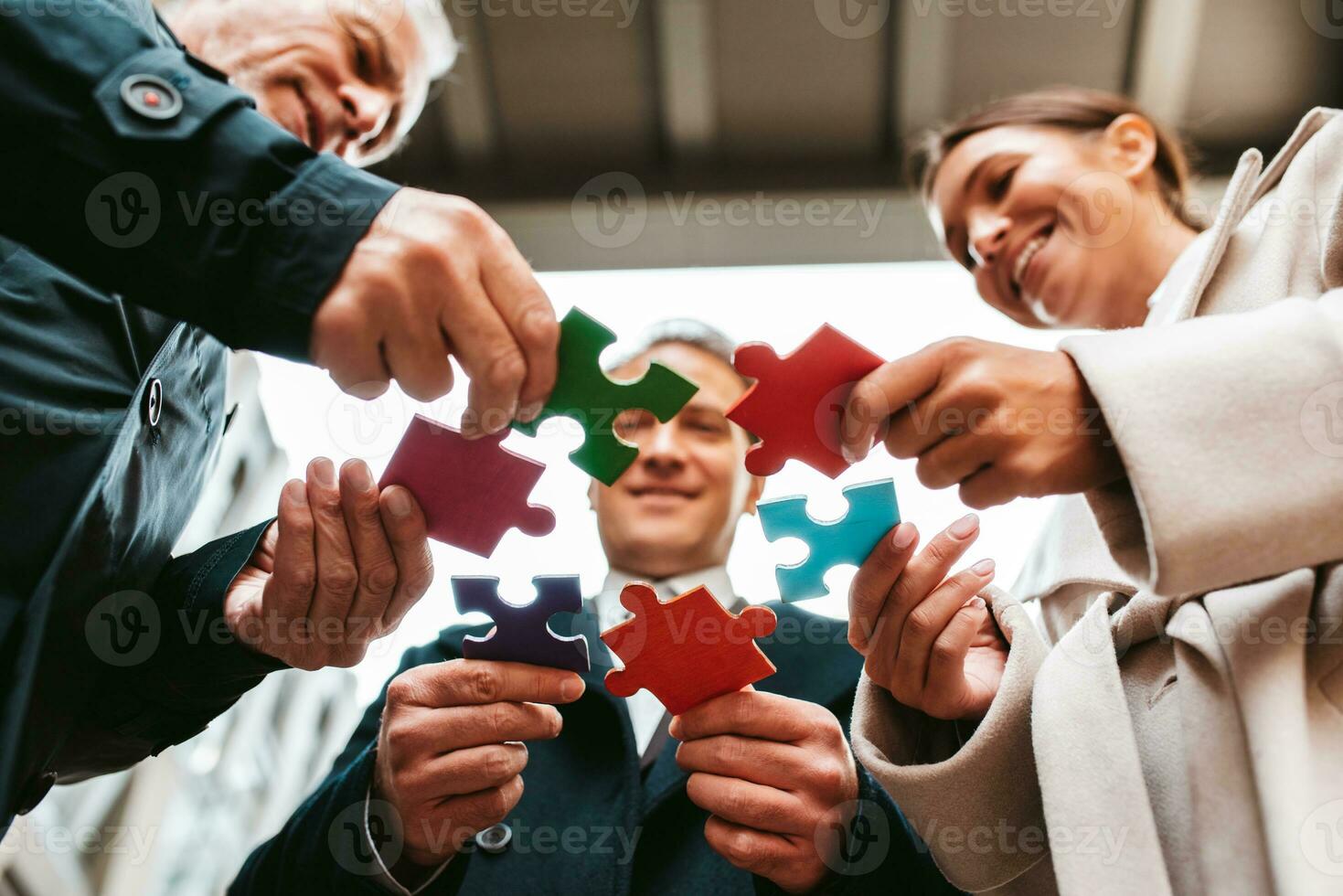 Businessmen working together to build a puzzle as teamwork, partnership and integration concept photo