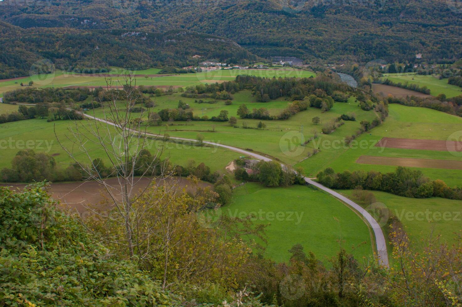 a view of a valley with a road and a train photo