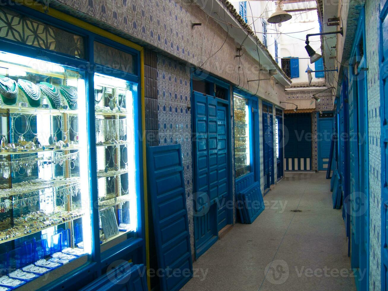 un estrecho pasillo con azul y blanco loseta paredes foto