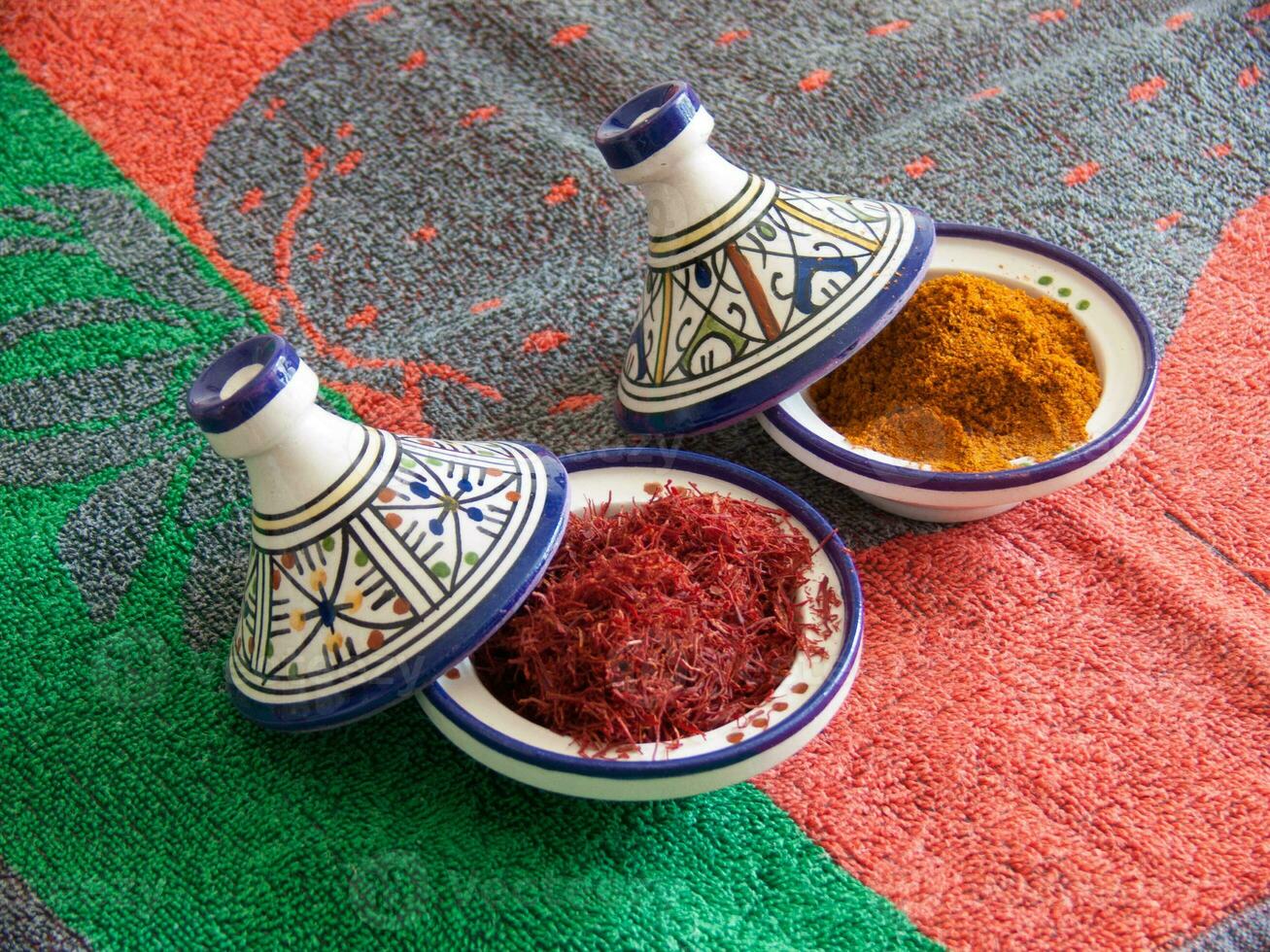 two small bowls with spices on a colorful rug photo