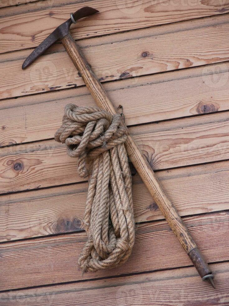 a rope and a pick on a wooden wall photo