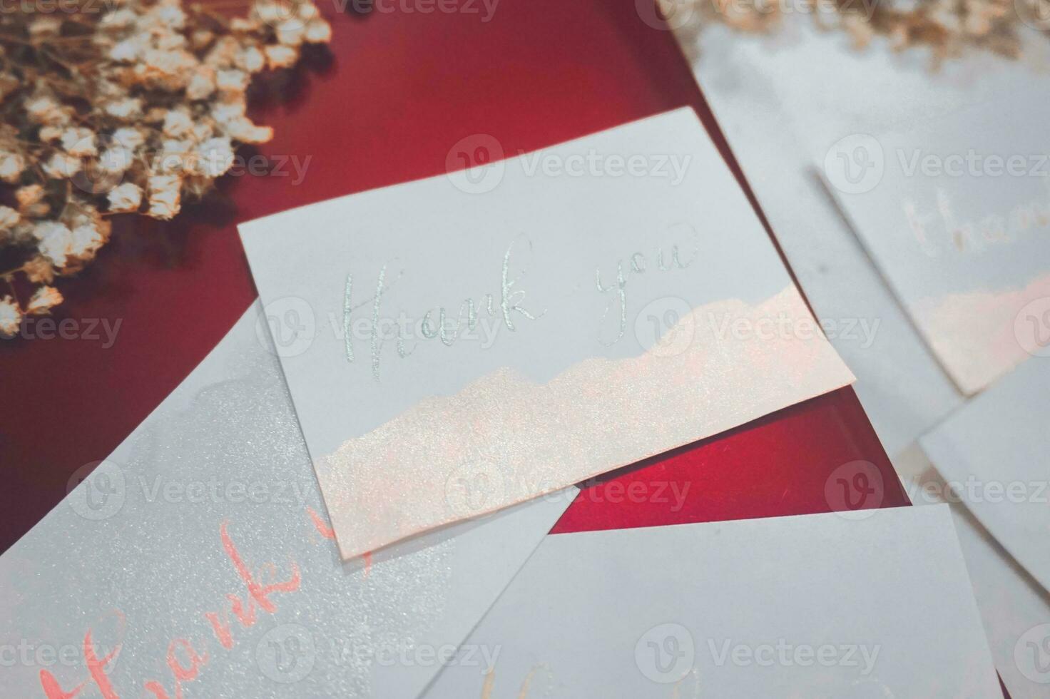Card with text thank you and dry flowers on white wooden background photo