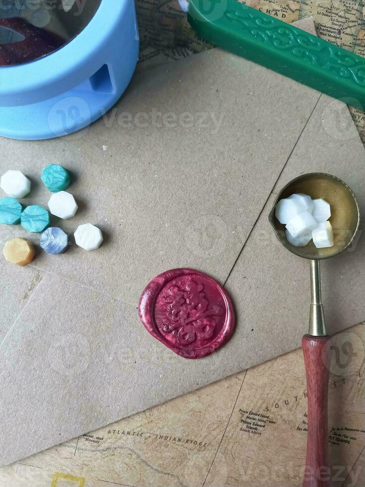 a vertical shot of wax coin with ribbon, wax bead on grey surface photo