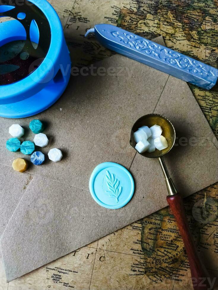 a vertical shot of wax coin with ribbon, wax bead on grey surface photo