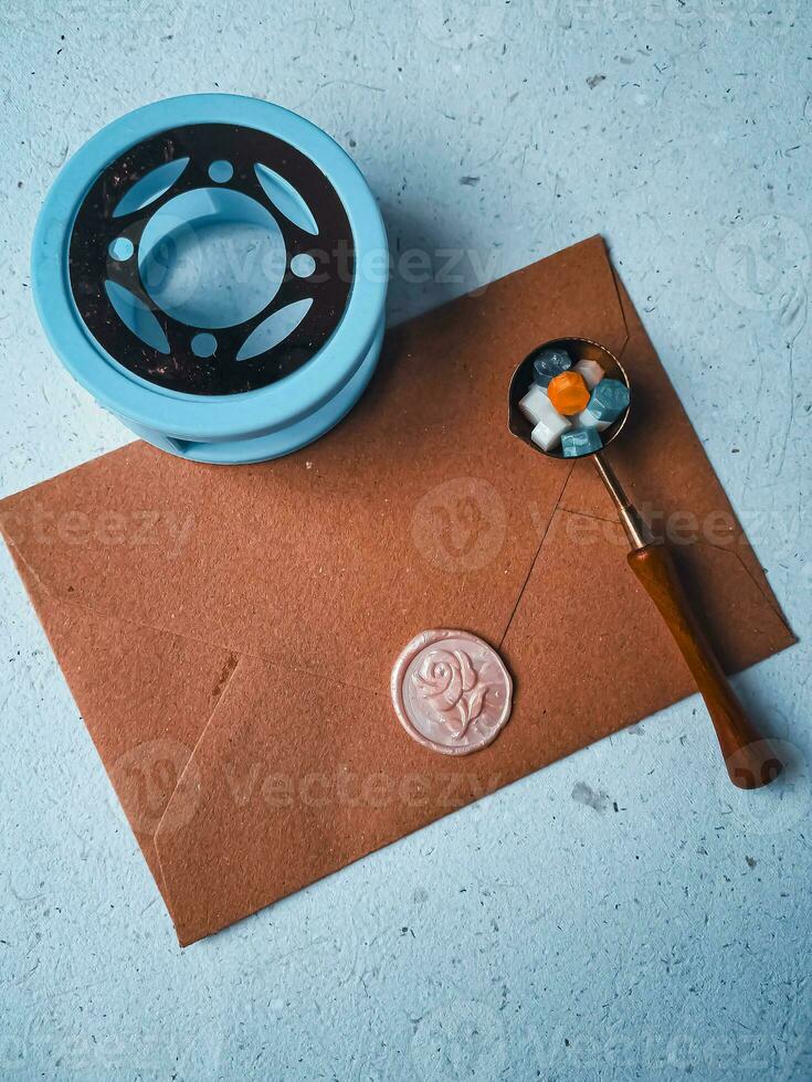a vertical shot of wax coin with ribbon, wax bead on grey surface photo