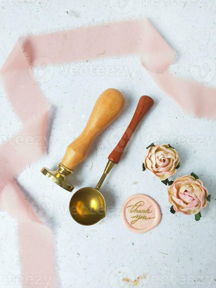 a top view of colorful wax bead and sealing wax with green silk ribbon on an old grey surface photo