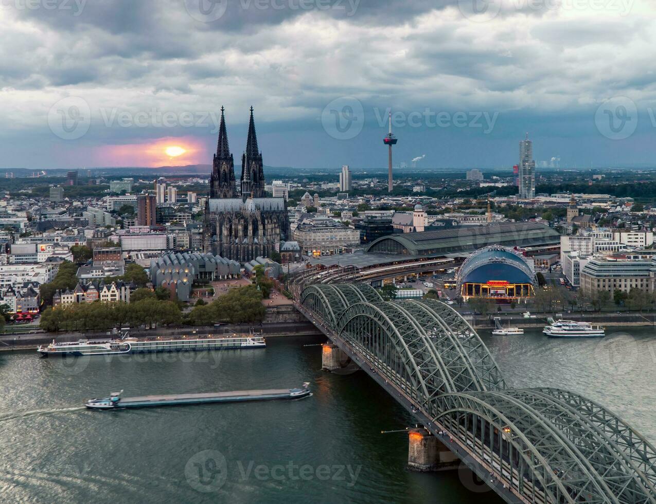 Dramatic storm clouds over Cologne Cathedral and Hohenzollern Bridge in the sunset photo