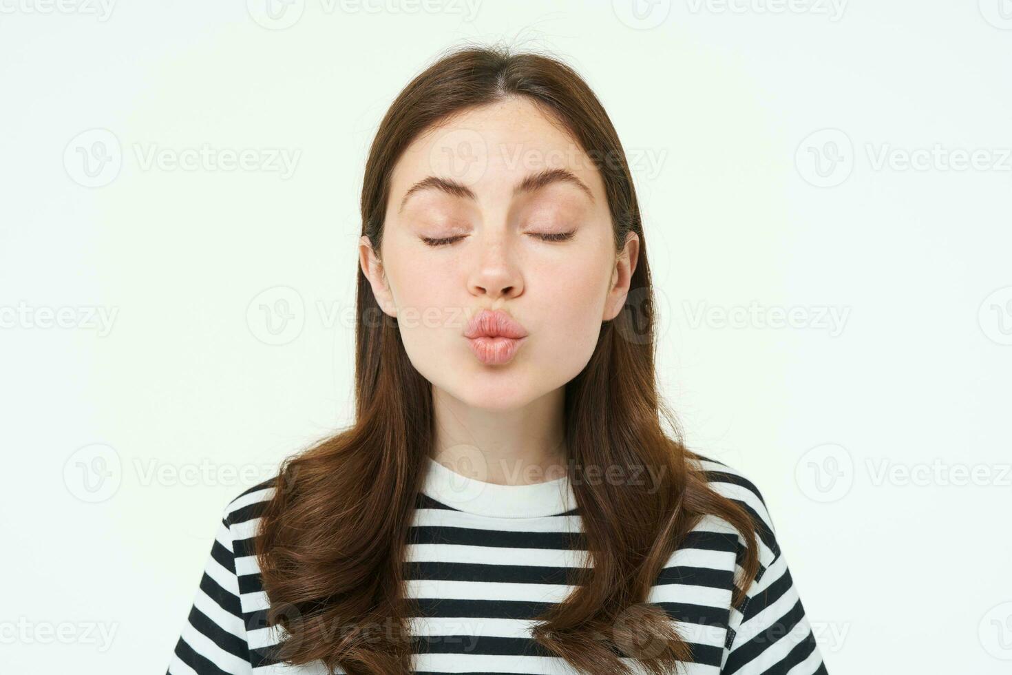 Portrait of woman stands with closed eyes and waits for kiss, pucker lips, kissing, isolated over white background photo