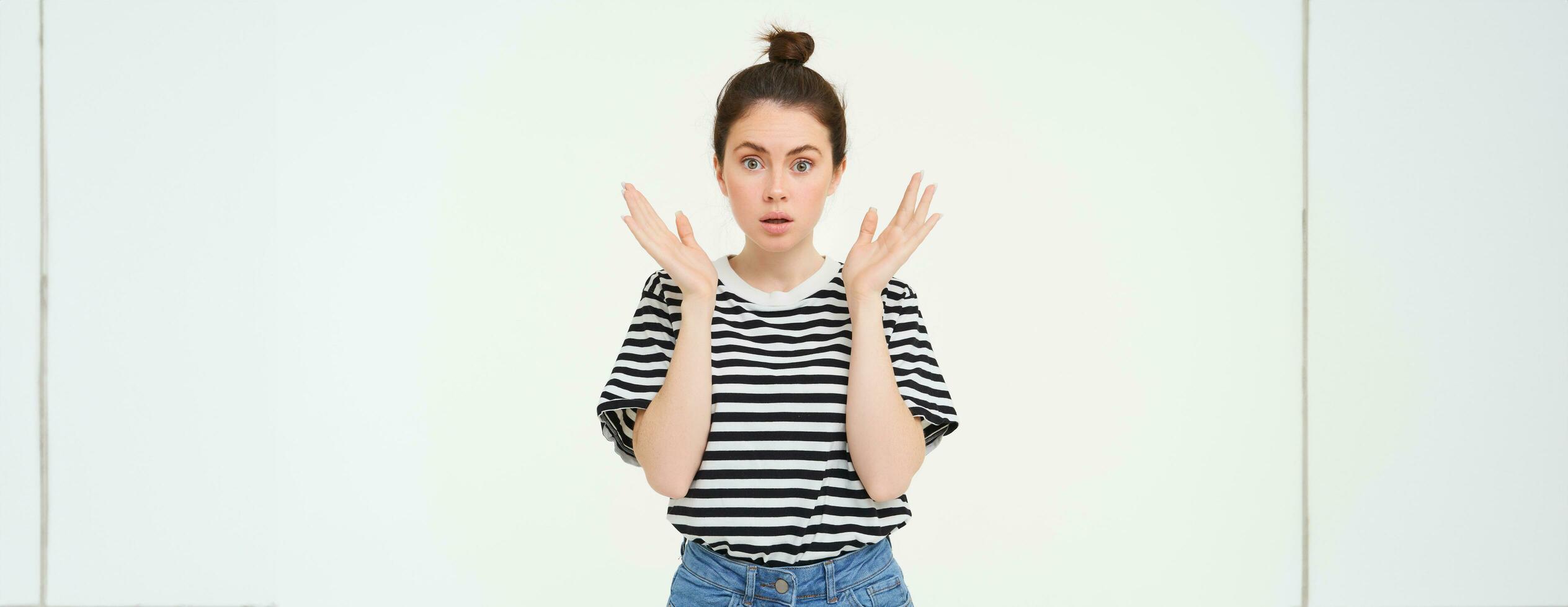 Portrait of surprised woman gasping, looking amazed, hear great news, drops jaw, says wow, impressed by something, stands over white background photo