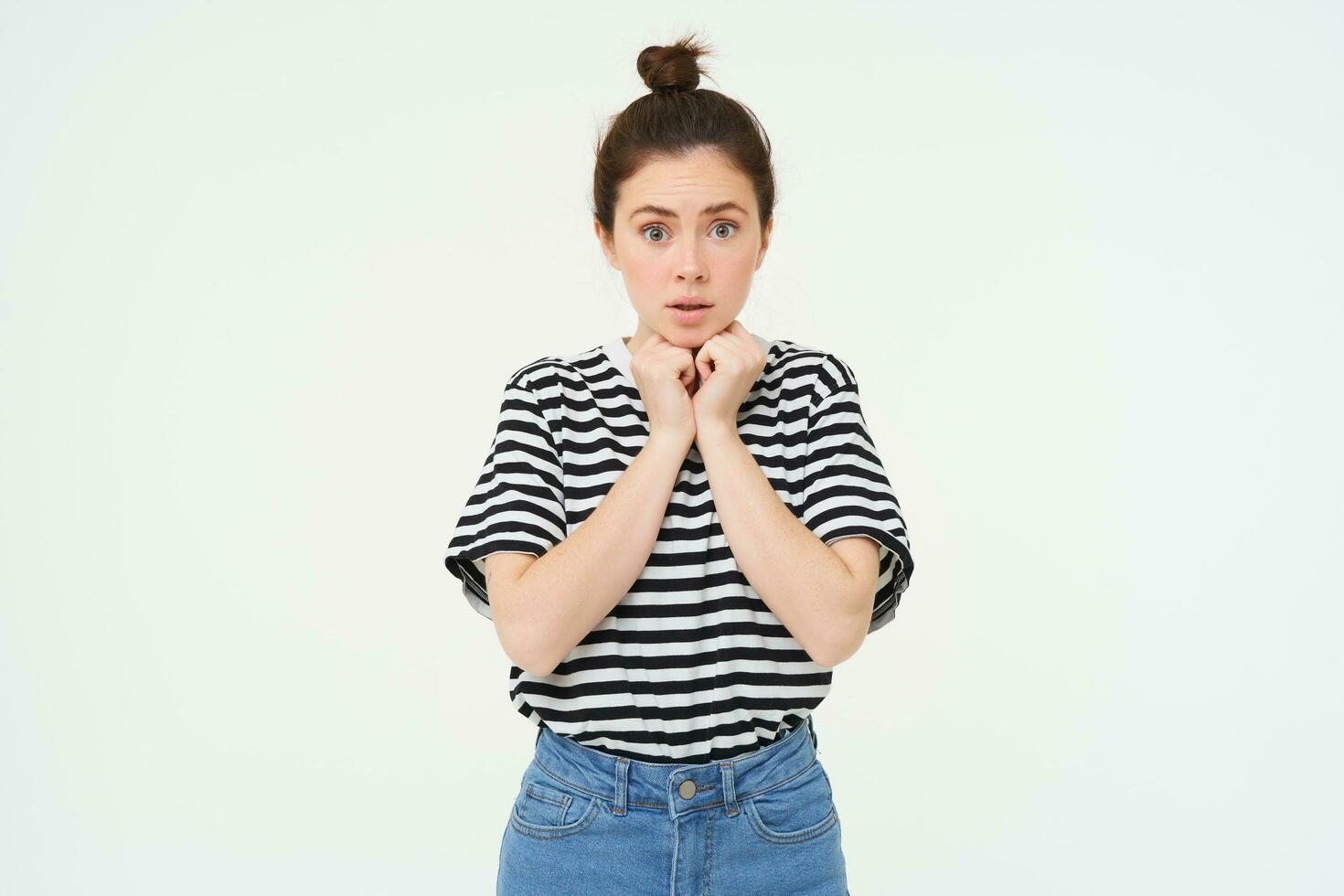 Portrait of young compassionate woman, looking with sympaty, gasping at camera, raising eyebrows, standing over white background photo