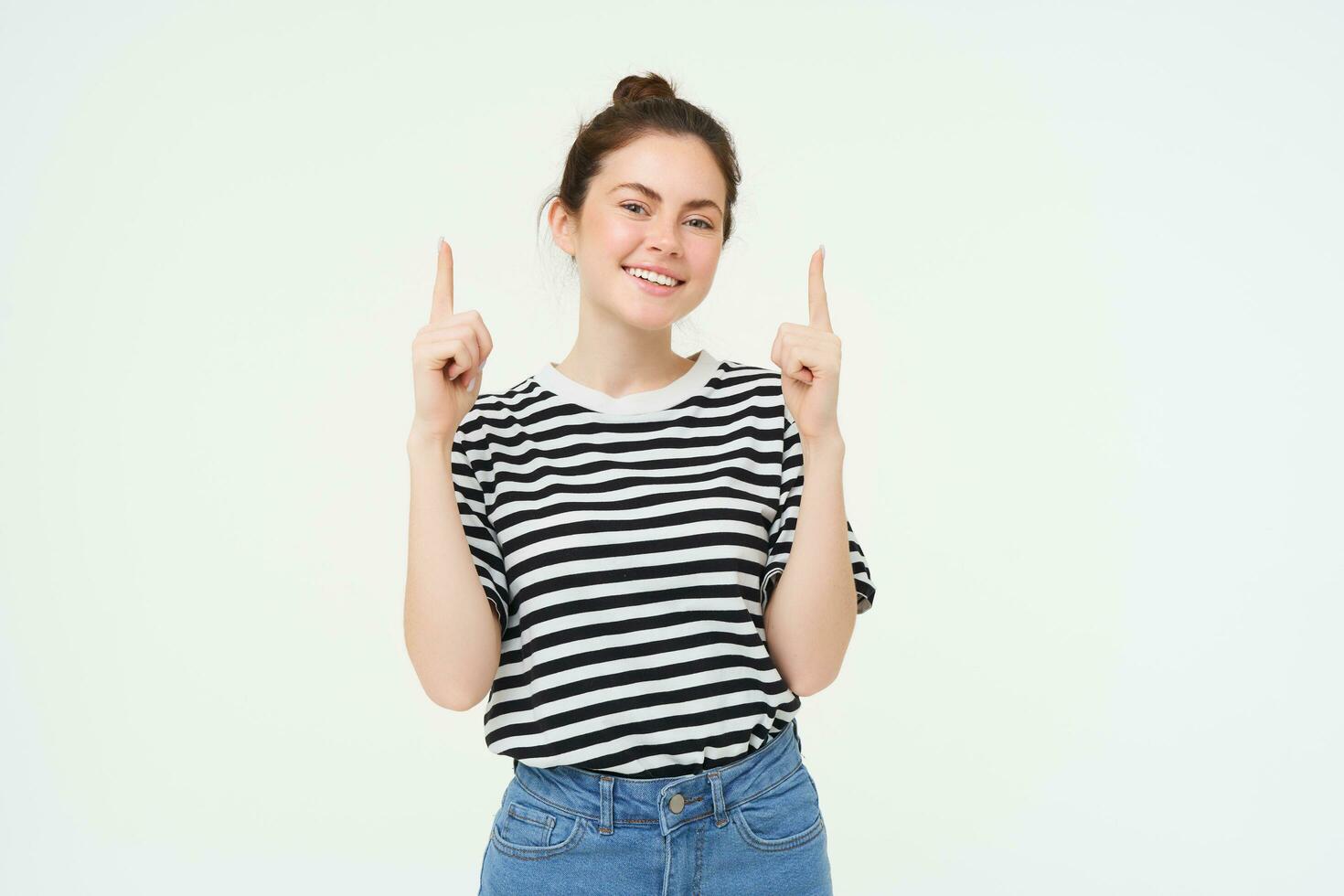 Lifestyle and advertisement concept. Young smiling woman, modern girl, pointing finger at promo, showing banner, place with text, isolated on white background photo