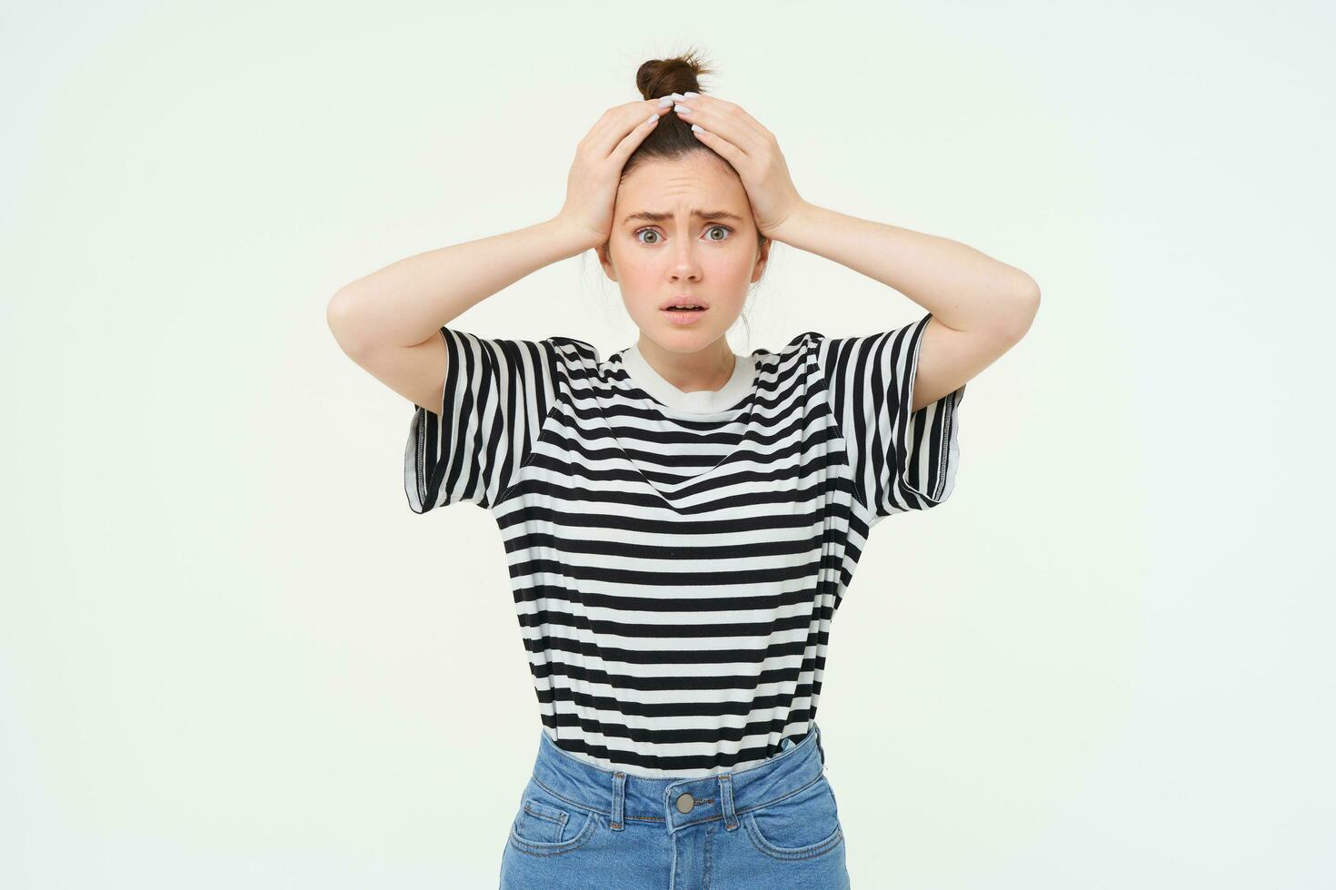 Portrait of woman in trouble, holding hands on head and panicking, looking worried, isolated over white background photo