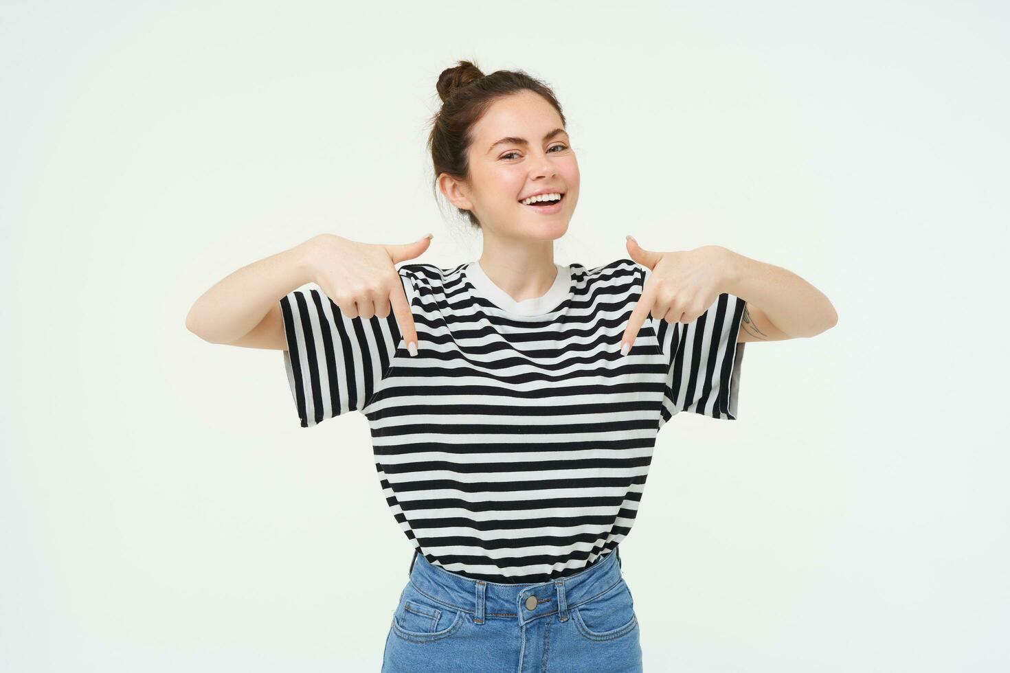 Carefree woman showing advertisement below, follow link on bottom, standing over white background photo