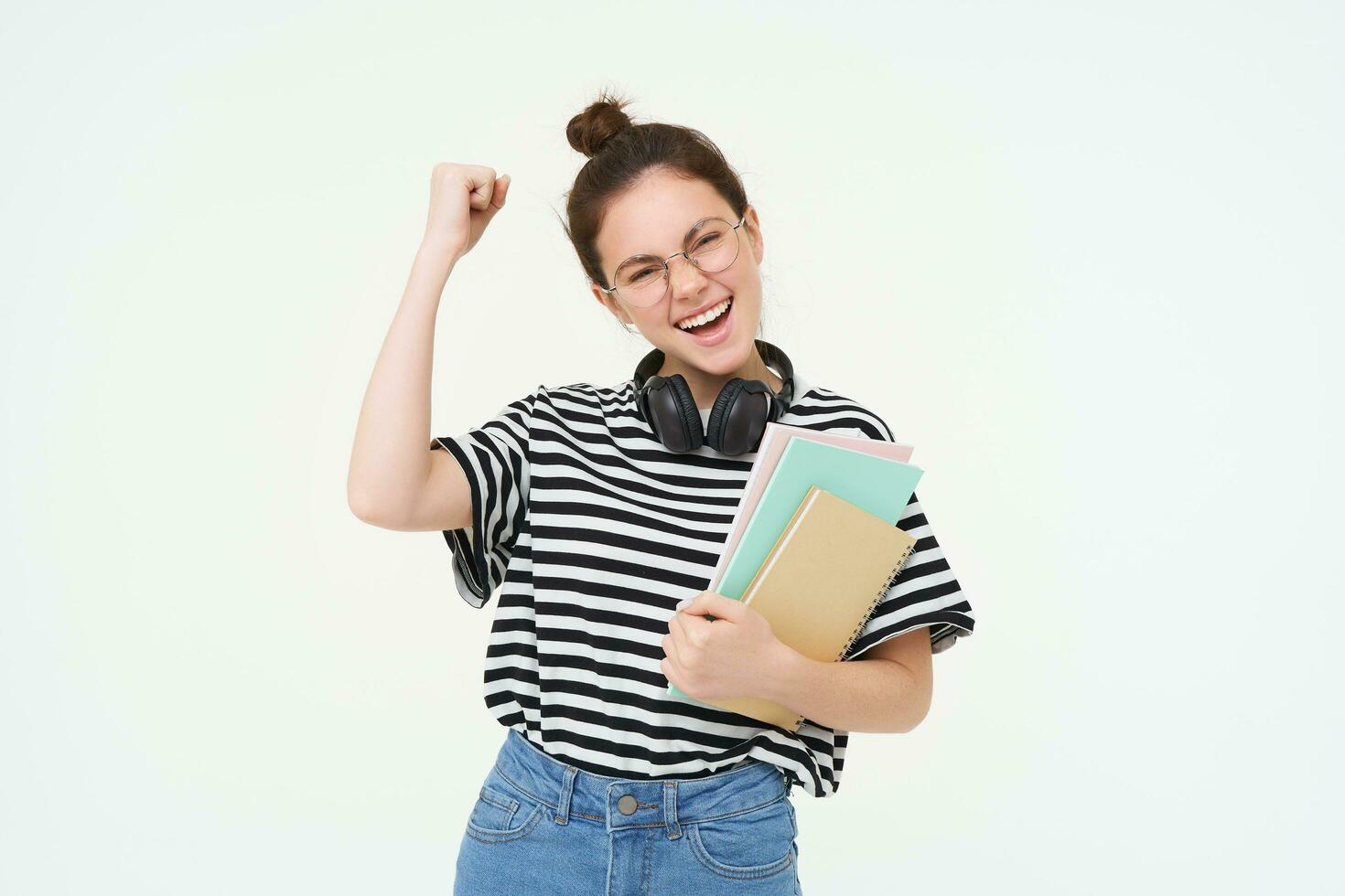 Enthusiastic young woman in glasses, teacher celebrating, raising hand up and cheering, tirumphing with joyful smile, white background photo