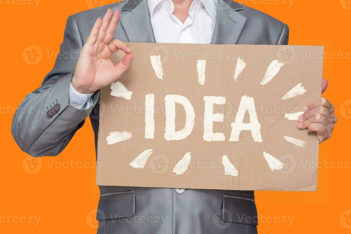 man holds in his hand a sheet of cardboard with a crudely painted inscription idea and shows OK, isolated on white background photo