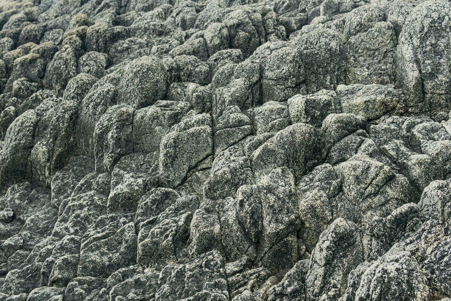 natural stone background, the remains of lava basalt columns form a relief surface photo