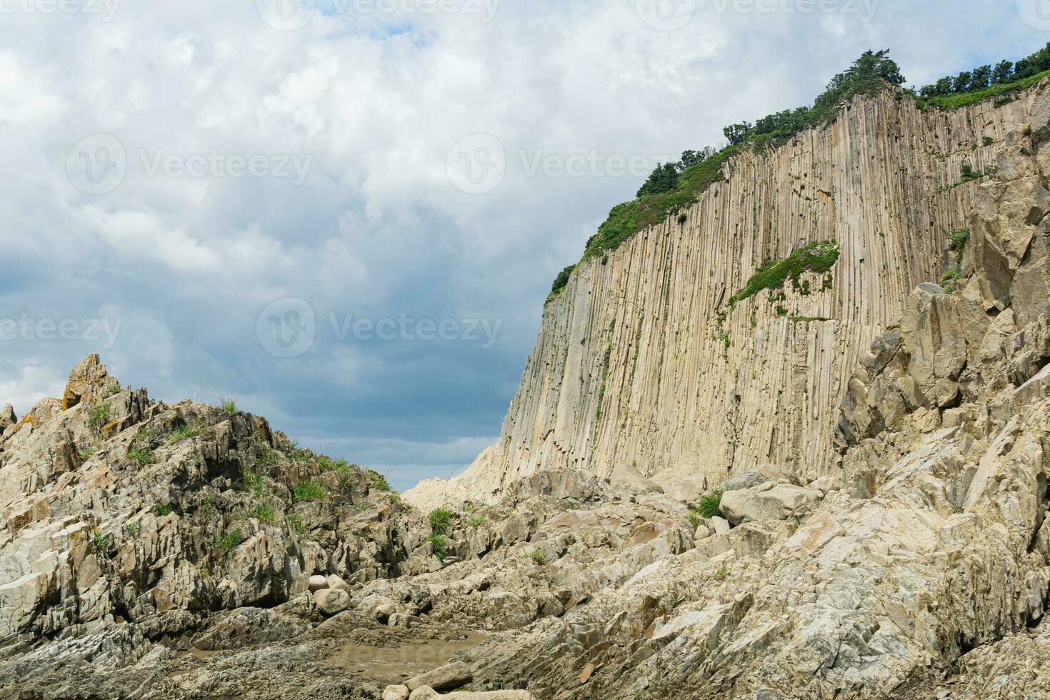 high coastal cliff formed by solidified lava stone columns, Cape Stolbchaty on Kunashir island photo