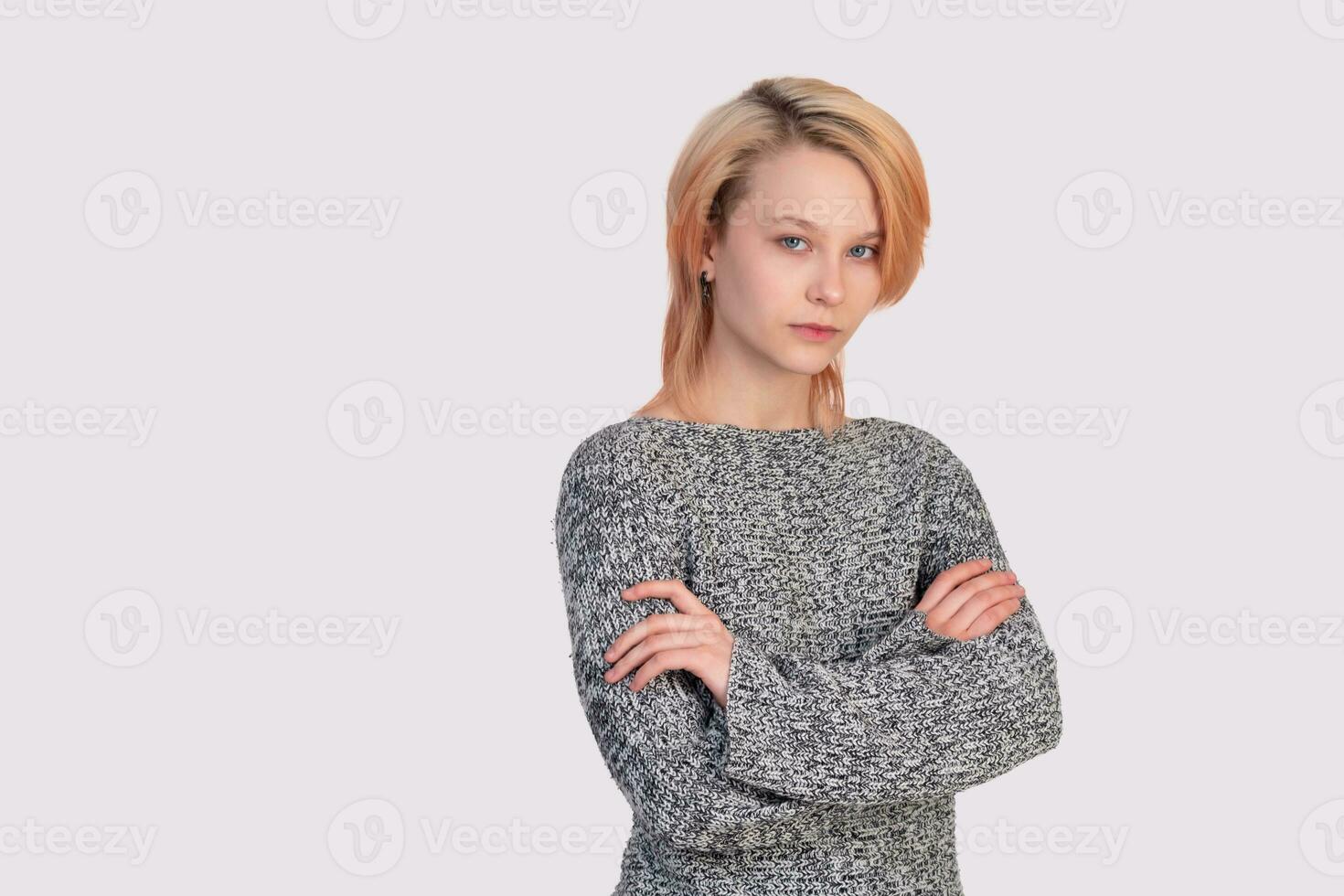 girl teenager in a closed position looks into the frame isolated on a light background photo