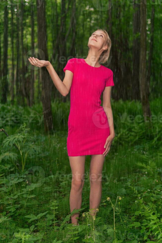 beautiful girl caught in the summer rain while walking in the forest photo