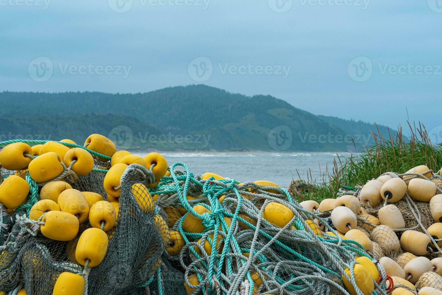 industrial fishing net with bright floats is folded on the seashore against  the backdrop of distant coast 35871394 Stock Photo at Vecteezy