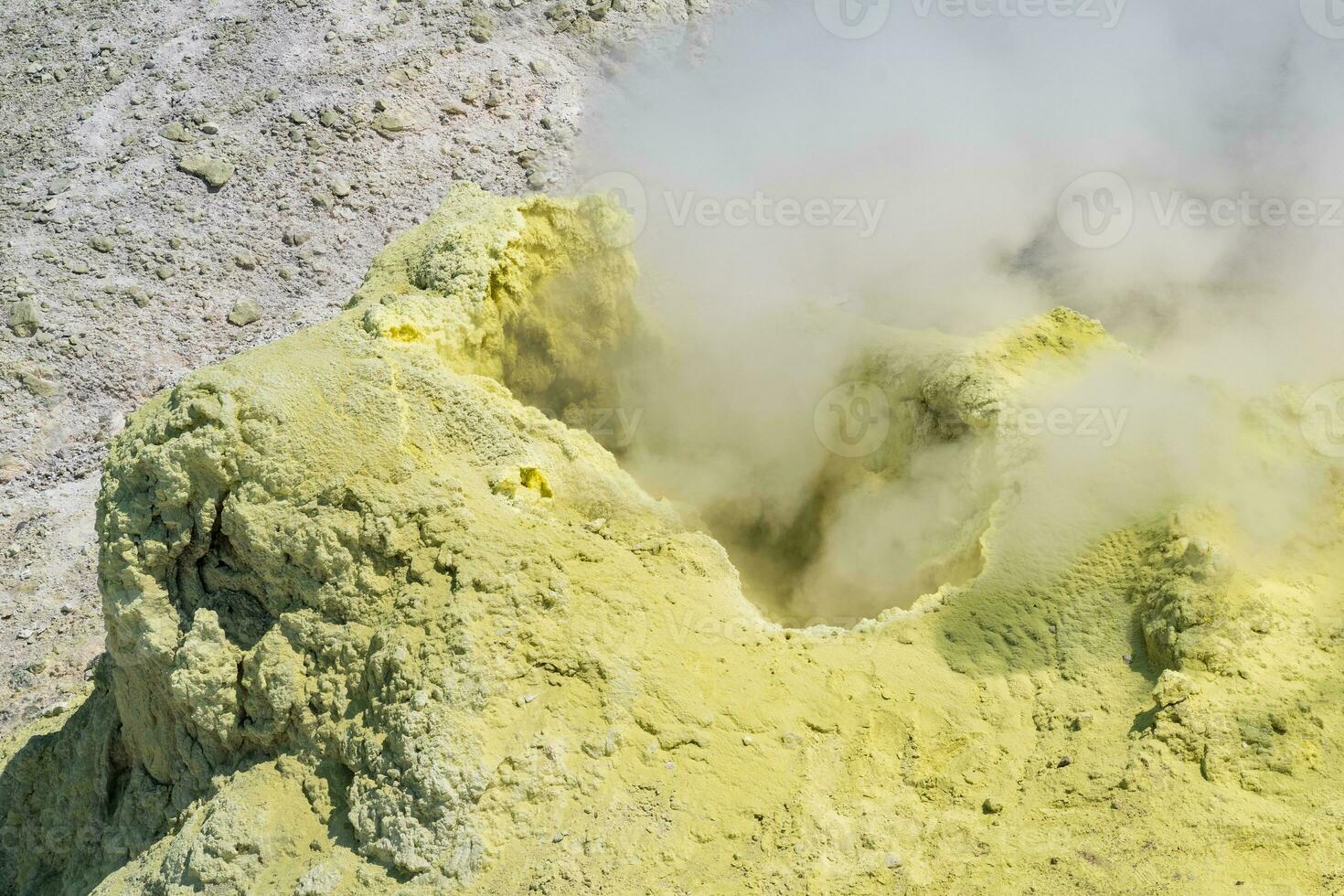 smoking solfatara among sulfur deposits on the slope of the volcano photo