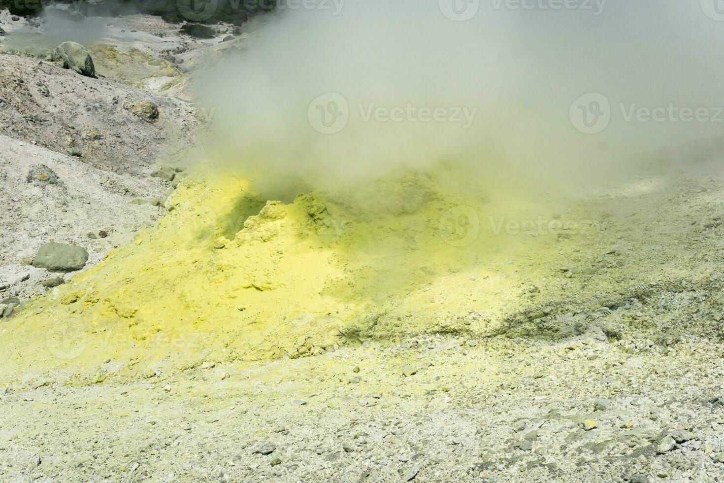 smoking solfatara among sulfur deposits on the slope of the volcano photo