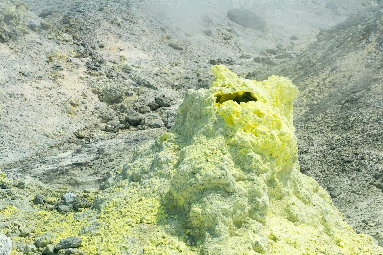 sulfur deposits around a solfatara in a fumarole field on the slope of a volcano photo