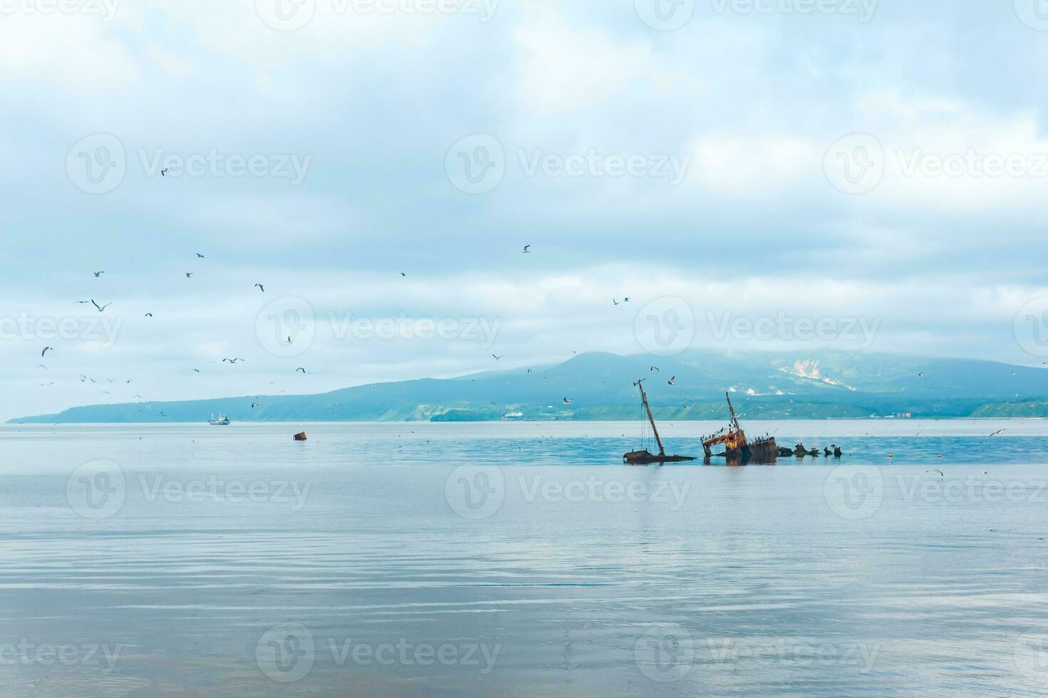shipwreck against the backdrop of a sea bay with foggy mountains in the background photo