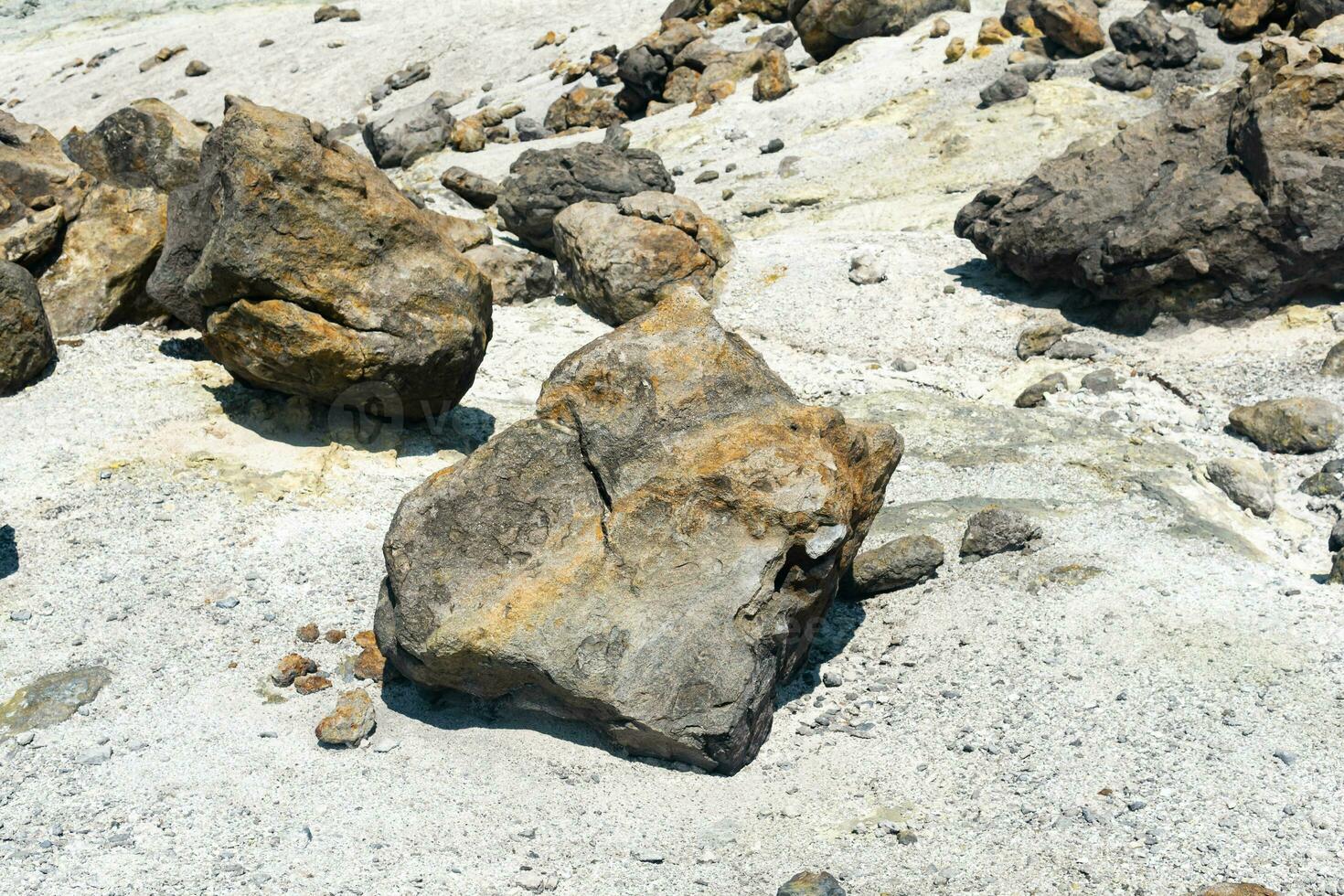 volcanic bombs among the tephra in a fumarole field on the slope of a volcano photo