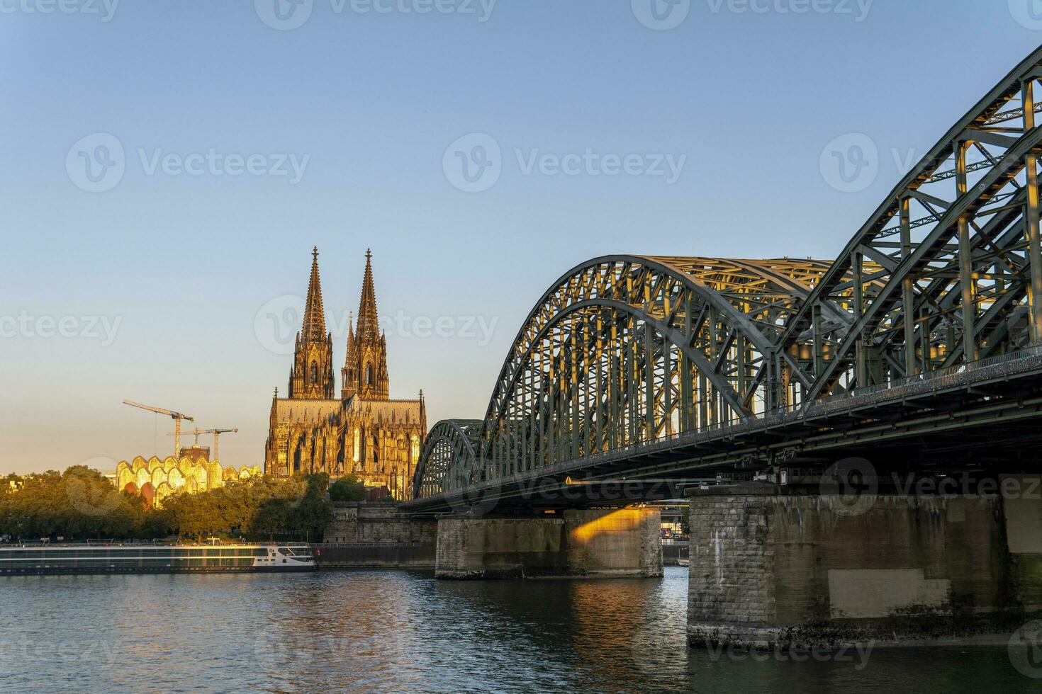 Cologne Cathedral and Hohenzollern Bridge illuminated by the morning sun photo