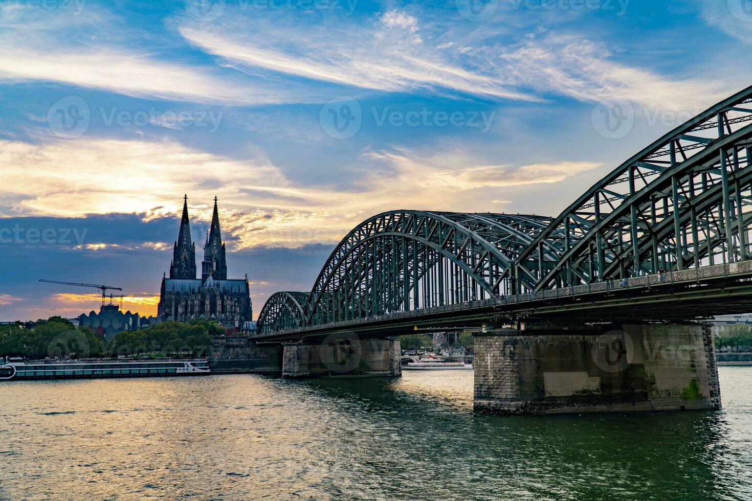 Cologne Cathedral and Hohenzollern Bridge at sunset cloudy sky photo