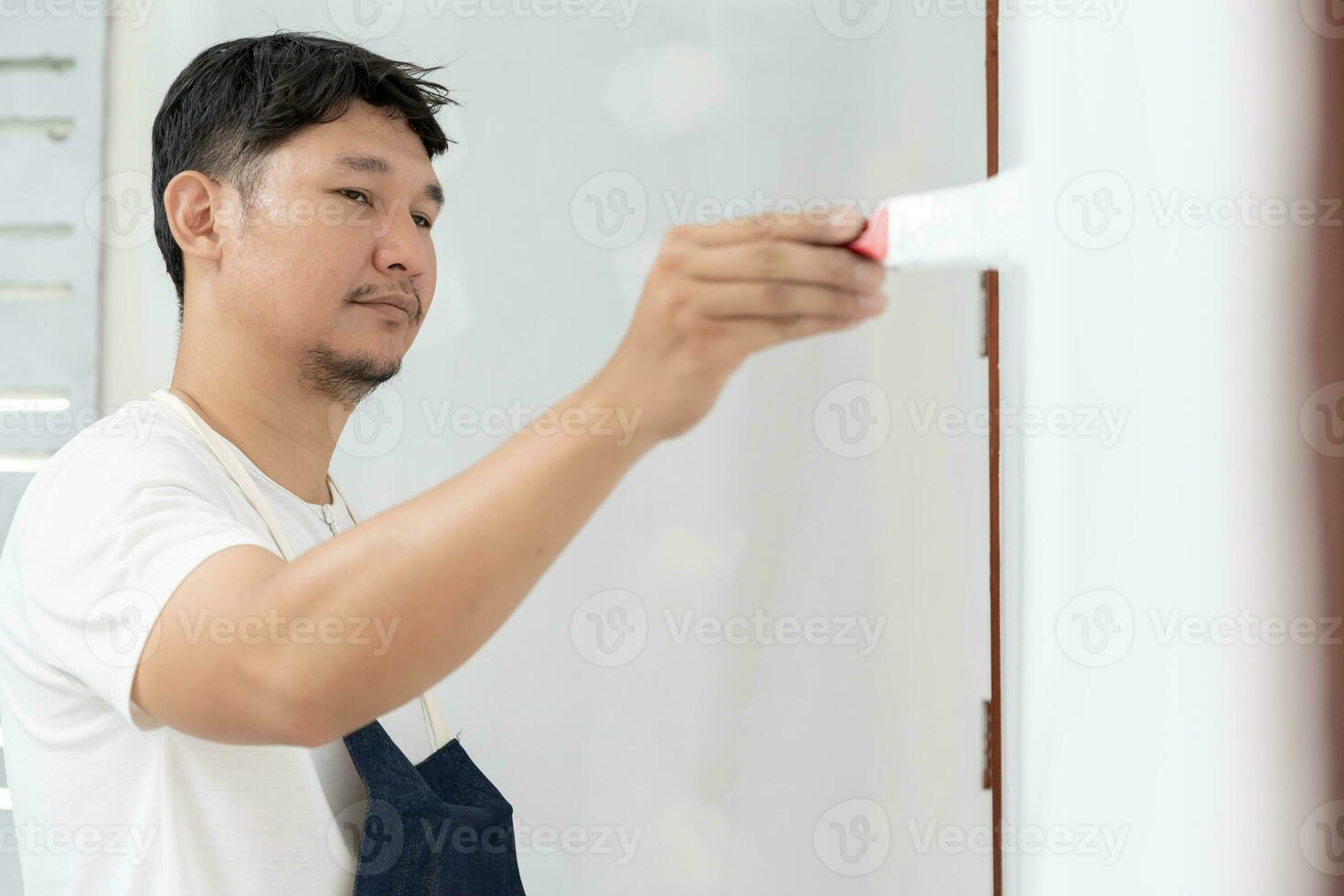 painter man, brush in hand for products to restore and paint the wall, indoor the building site of a house, wall during painting, renovation, painting, contractor, Architect, construction worker photo