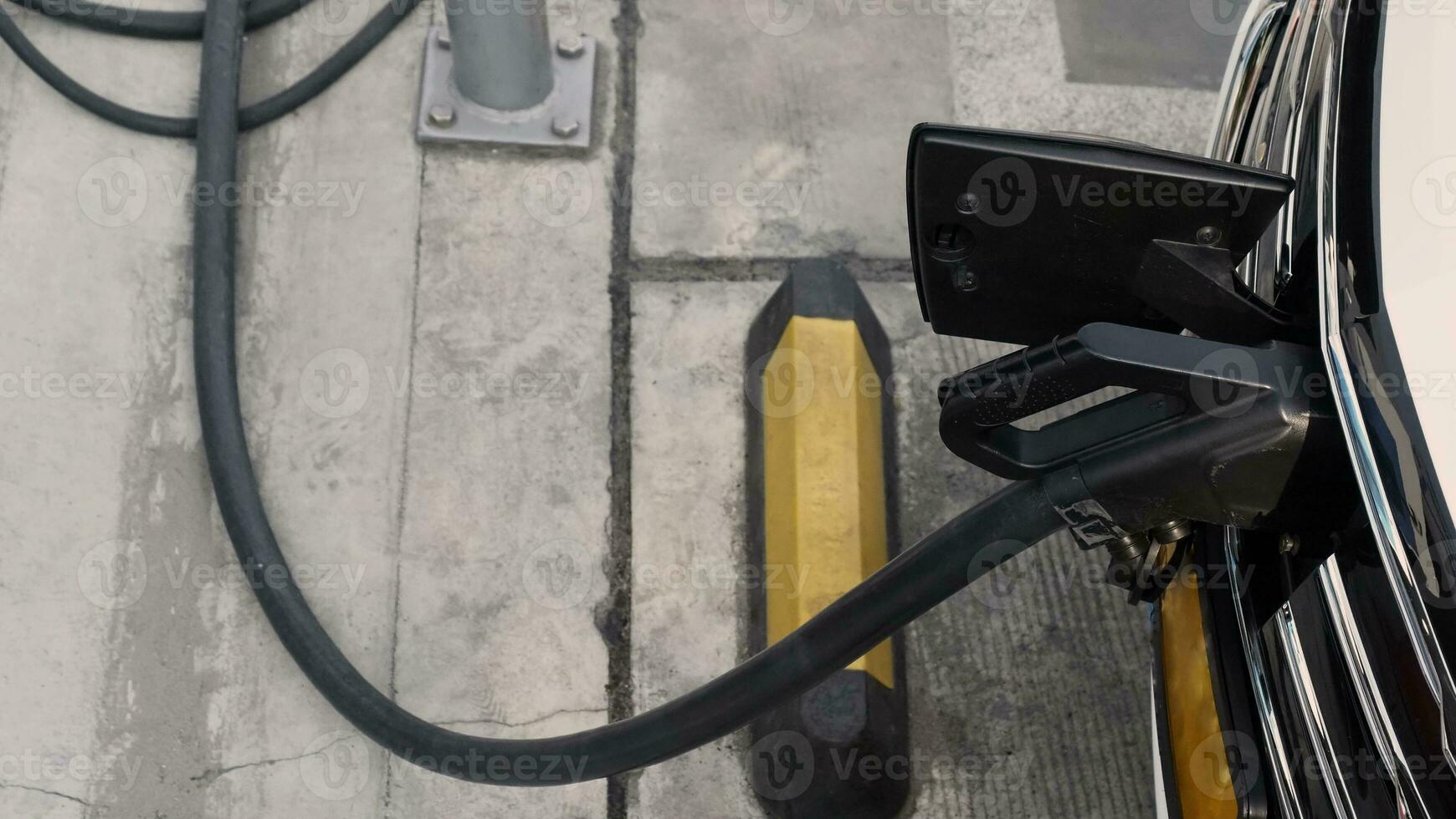 Electric Vehicle car or EV Car parking at charging station and plugged power cable supply. Charge power to EV or hybrid car battery. Green energy and eco power of World future transportation. EV power photo