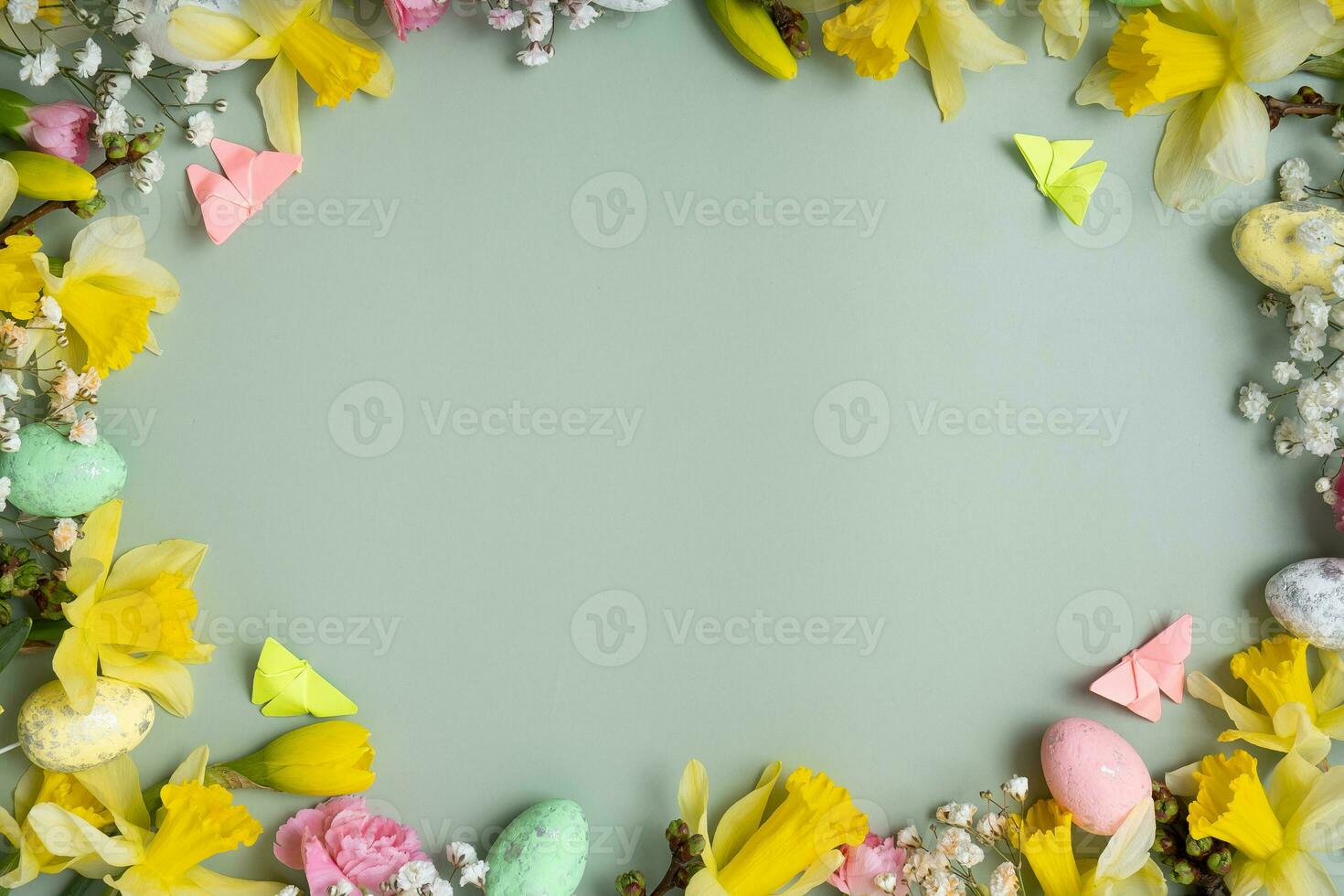 Spring flowers ans easter eggs border on green background with copy space. Easter greeting card template photo