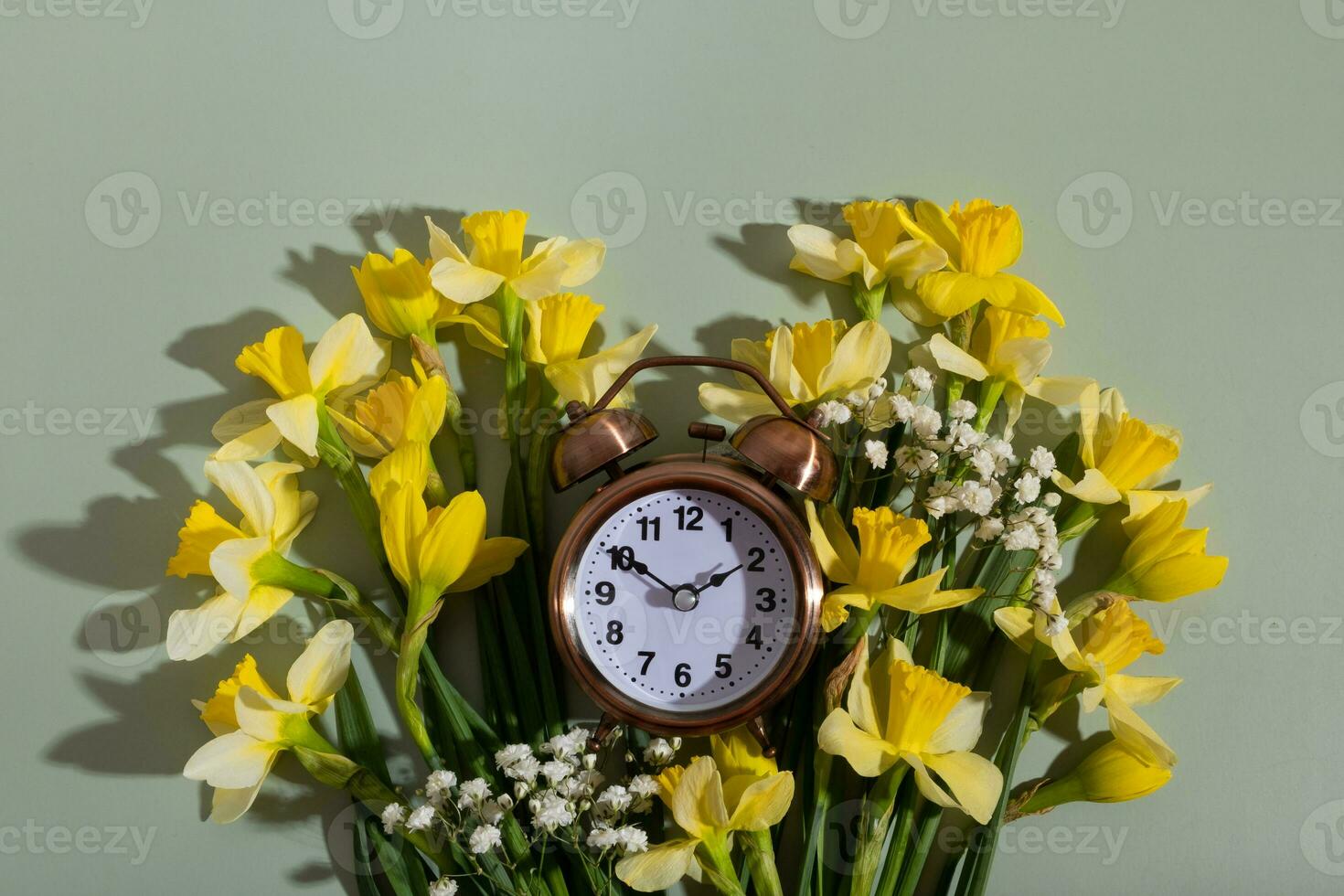 Alarm clock with spring flowers. Spring time, daylight savings concept, spring forward photo